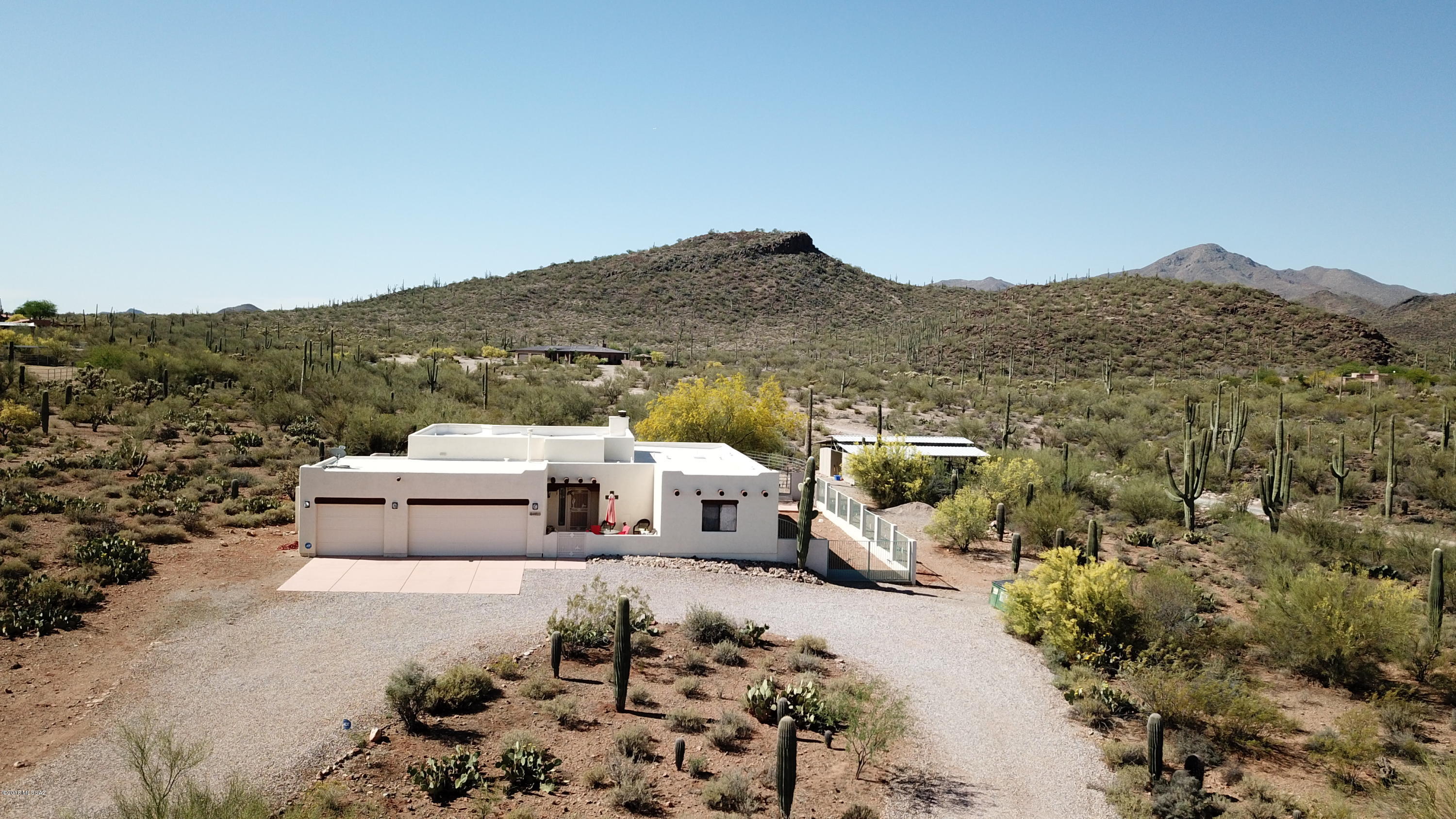 First time offered in MLS. Quality Sombra built home on nice high 3.3+ acre view lot. High ceilings, great room concept. Recently painted inside, clean and sharp turn key home. Large picture windows offer views of Saguaro National Park. Seller may sell furnishings. Cozy front courtyard has sparkling lights, Sombrero Peak and sunset views. Set up for the equestrian enthusiast, four horse mare motel with tack room and feed room. One additional corral is covered, wash rack, round pen. Excellent winter home potential as well. Trail access into Saguaro National Park Veterans Trail right from the property.