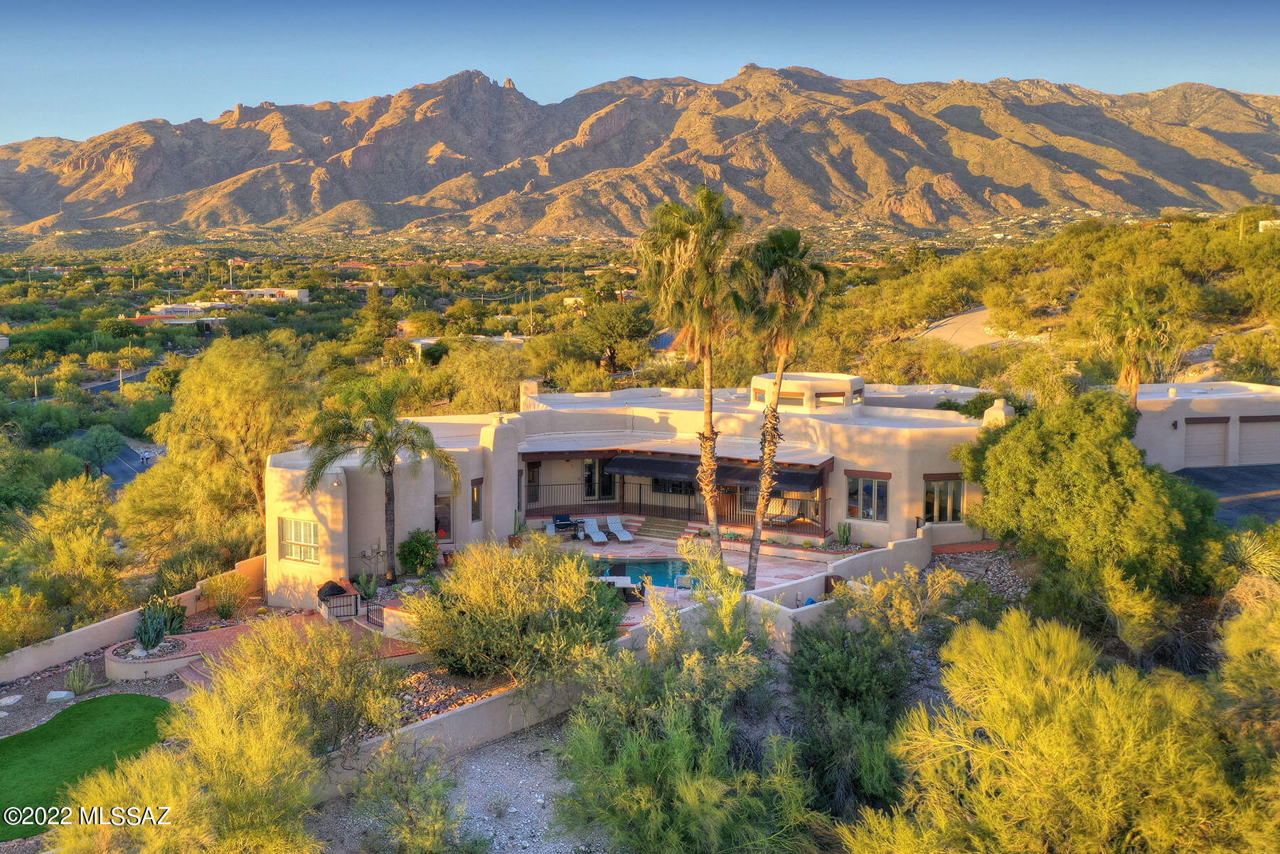 Architecturally unique home w/ MAGNIFICENT PANORAMIC VIEWS that will take your breath away. This soft contemporary, 5BR/4BA w/Santa Fe touches, is perfectly situated on one of the best lots in sought after guard gated Catalina Foothills Estates #10. Gated courtyard opens to dramatic foyer, high ceilings, wood beams, scored concrete floors & floor to ceiling Pella windows capturing spectacular mountain, city & sunset views. Custom designed kitchen w/ top of the line SS appliances, gourmet island & granite counter tops. Enjoy morning coffee gazing at nature's beauty from large breakfast room wi/access to north facing patio. Gracious dining & living rooms are ideal for entertaining. Plus enjoy the sound proofed media or family room.  See more... Primary Suite inc beehive fireplace, luxurious BA & walk-in closet w/built-ins. Private guest quarters has full BA, fireplace & patio. Enjoy Tucson's outdoor life style in the resort-like backyard w/an extended ramada, sparkling pool, multiple patios & beautiful area perfect for a play yard, putting green or entertaining. The very large laundry room has an abundance of storage & is large enough to use as a craft room. XL 3 car garage, tons of privacy. all on a 2+acre lot. District 16 schools. Close to dining, shopping, schools, recreation & more. Welcome Home!
