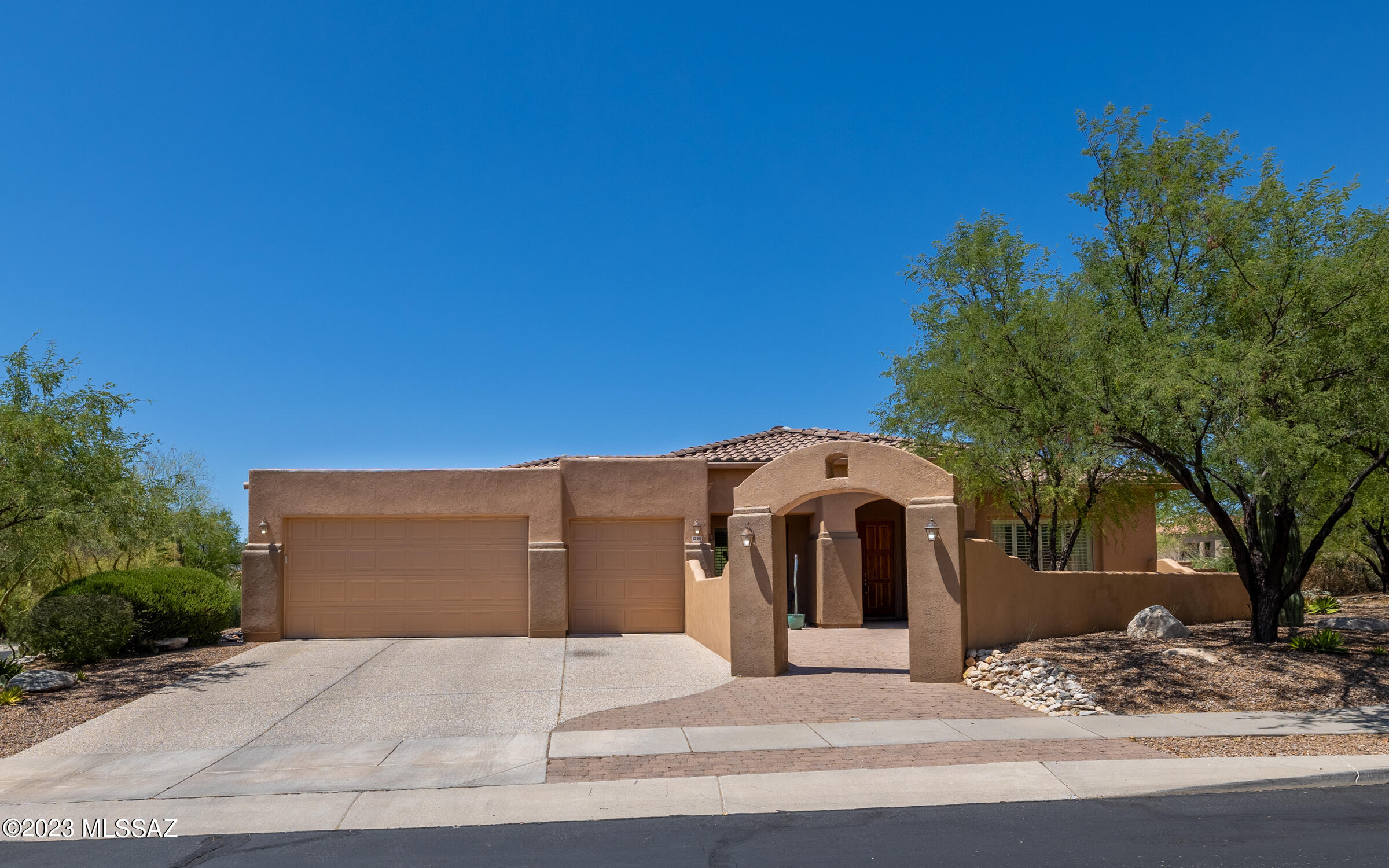 OV beauty, nestled on .68 acre, cul-de-sac lot in a lovely gated community welcomes you w/a bold, lighted archway, huge brick paver courtyard, mature vegetation, seating area, covered patio & leads to a double door entry! You're immediately welcomed w/oversized, gorgeous diagonal set tile, tall ceilings, all new light fixtures/fans, fresh interior paint, beautiful arches, & an open floor plan w/a gas fireplace. The kitchen boasts maple cabinetry, granite counters, gas cooktop, center island, breakfast bar, pantry, & kitchen nook. Living room offers a cozy feel w/built-in shelving, perfect for books/ show pieces. You'll love the primary bedroom & guest ensuite! Most rooms have views of rear covered porch, HUGE ext paver patio, pool, spa, outdoor kitchen/fireplace. SEE VIDEO & UPGRADE SHEET
