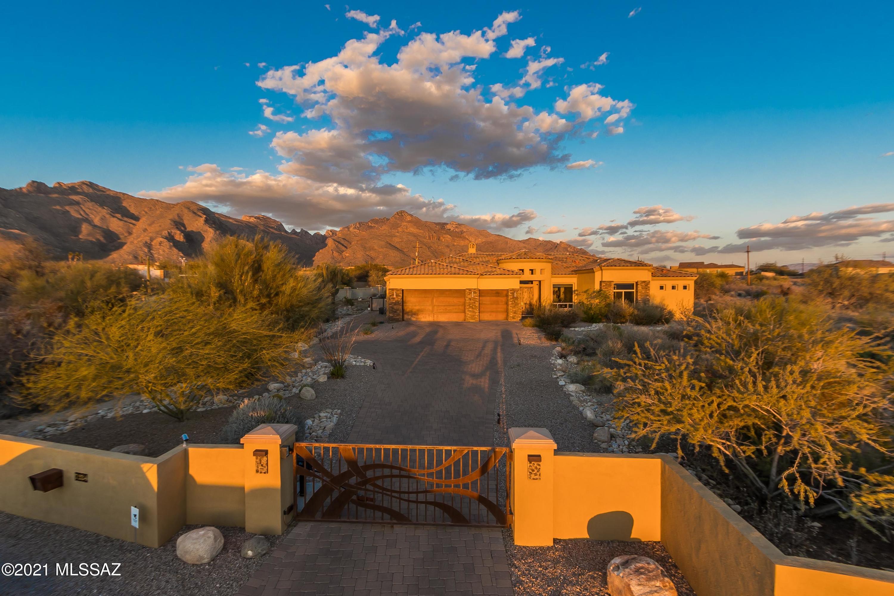 Sellers will accept offers between   $1,000,000 - $1,310,000. Can be sold fully furnished if buyer is interested! Stunning contemporary home with breath taking views of the Catalina Mountains, loaded with upgrades is ready for it's new owner!  Prepare to be amazed by the high end finishes and attention to every detail as you enter through the custom remote gated entry and up the paver drive a 3 car garage. The entry is grand with custom solid wood double front doors.  Inside, a formal dining room with upgraded lighting offers views of the western mountains and sunsets. Formal living area with modern gas fireplace offers majestic views of the mountains to the East through a wall of windows. The kitchen is a (CONTINUED)... Chef's dream with high end cabinetry, stainless appliances, custom backsplash & a breakfast bar robed in reclaimed wood. Kitchen opens to stunning great room with custom wood wall, decorator paint palette and custom designed window treatments. The Master bedroom is a jaw dropper. 3D wood block wall and upgraded bedside light fixtures and windows highlighting those gorgeous Catalina views. The en suite features a soaking tub, walk in shower, dual vanities and his and hers closets with California closet systems. Outside, the covered patio seating area with gas firepit overlooks a perfectly designed and low maintenance backyard with raised entertaining platform covered in travertine from the Ritz Carlton, built in grill, double gates on the North side for beauty and convenience if pool is desired.  Please see additional list attached for full accounting of features. Must see this one of a kind masterpiece property!
