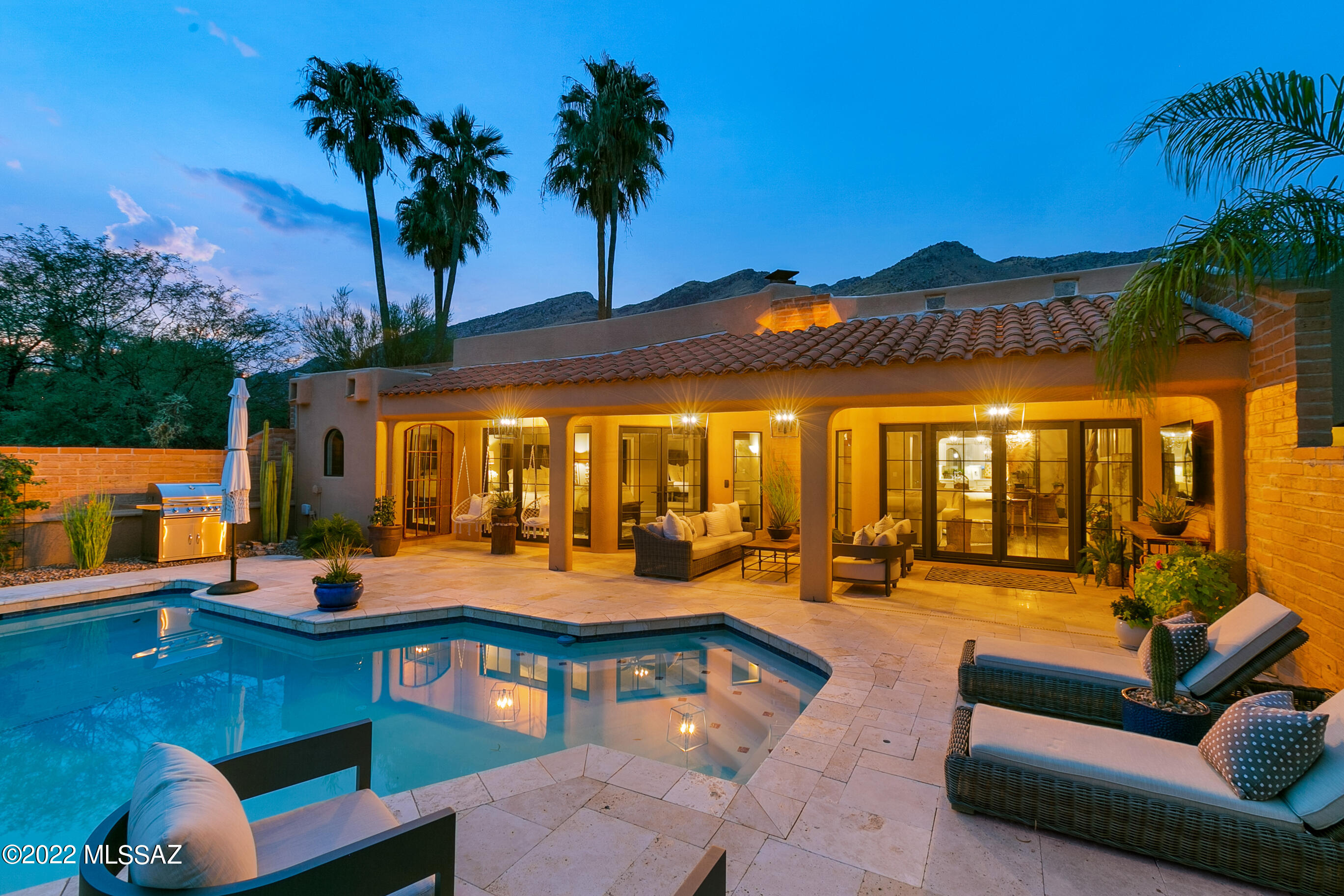 Be prepared to be impressed by the sellers well chosen updates/improvements.  Located directly in front of this home's courtyard entry is a grand fountain to welcome you!  Custom pavers & desert landscape lead to a French glass entry door and once inside you'll be delighted by the attention to detail.  High open beam ceilings, wood burning f/p and engineered hardwood floors. Marble kitchen counters, large pantry, French door breakfast nook,  Updated light fixtures adorn the house and add to the artistic flair.  Step out to the rear covered patio w/remodeled pool and travertine decking - take in the city lights at night! The large primary suite has French doors to the pool/patio while the primary bath has a jetted tub, dual sinks & large closet. Both guest bedrooms have mtn views.