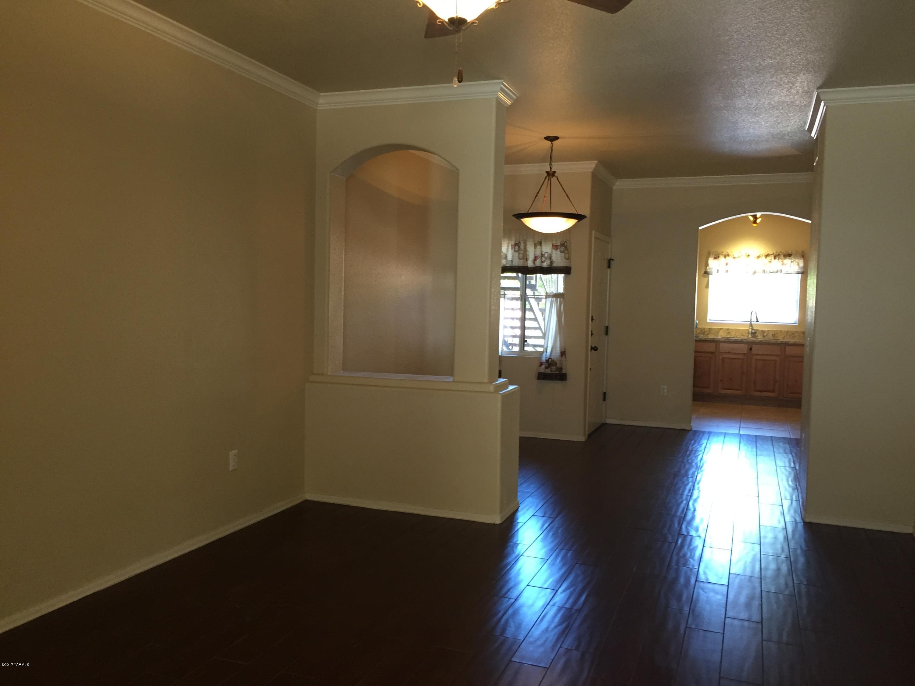 Ground floor 2/2, including A GARAGE and a carport space. Great private location at the back of the community, enclosed patio looking on to the desert behind, with peeks of the Catalina's through your kitchen window. Split floorplan, featuring wood floors in living areas, tile in bathrooms and carpet in bedrooms. This gated community features sparkling pool and spa, exercise facilities and clubhouse.Must see! Within walking distance to hiking, dining, shopping, +++!