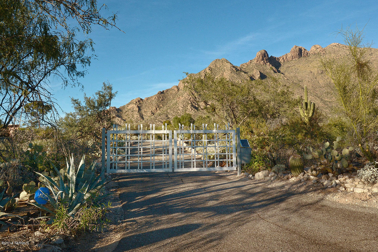 This perfectly positioned mid-century architectural gem, designed by renowned local architect Bernard Friedman, is nestled on 4+acres of lush Sonoran desert in desirable Cobo Catalina Hills. It takes full advantage of romantic Catalina Mountain and breathtaking city views from the glass walled interior to the expansive pool area and guesthouse. The spectacular new master suite has been completely remodeled by designer/architect Greg Simmons and interior designers Tom and Sue Lujan, creating a modern yet luxurious space with details including a dual sided see-thu gas crystal fireplace and pendant Swarovski crystal lighting. Privately gated. Main House 3296 SF/GH 692 SF + Workshop 224 SF not incl in total 3988.  A unique home in a remarkable privately GATED setting of the Catalina Foothills.