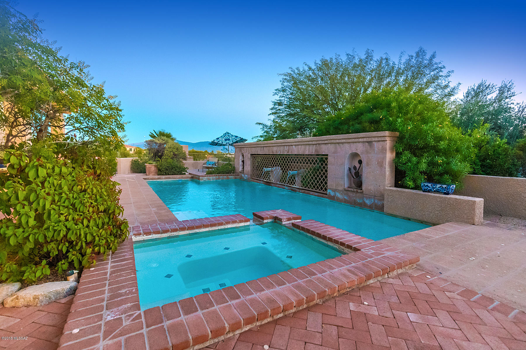 This incredible one-level w/NO STEPS, 5 bed, 5 bath  5875 Sq. Ft. all masonry home sited on 1.42 acre hilltop in coveted gated Catalina Foothills Estate No. 10 is now available. Interior features boast 24X24 Travertine flrs, lighted niches, recently remodeled gourmet kitchen w/dark Italian wood cabinets, granite counter tops & massive granite island w/butcher block top. Generous size en-suite bedrooms & library w/floor to ceiling bookshelves may also be used as 5th bedroom. Gracious master suite w/FP, jetted tub & door leading to patio. Spacious family room off kitchen w/beamed ceilings & large bar for seating for 4. Award winning backyard w/heated pool/spa w/water feature, outdoor kitchen, lower patio w/FP & amazing city, mountain, and sunset views is the perfect place to entertain.