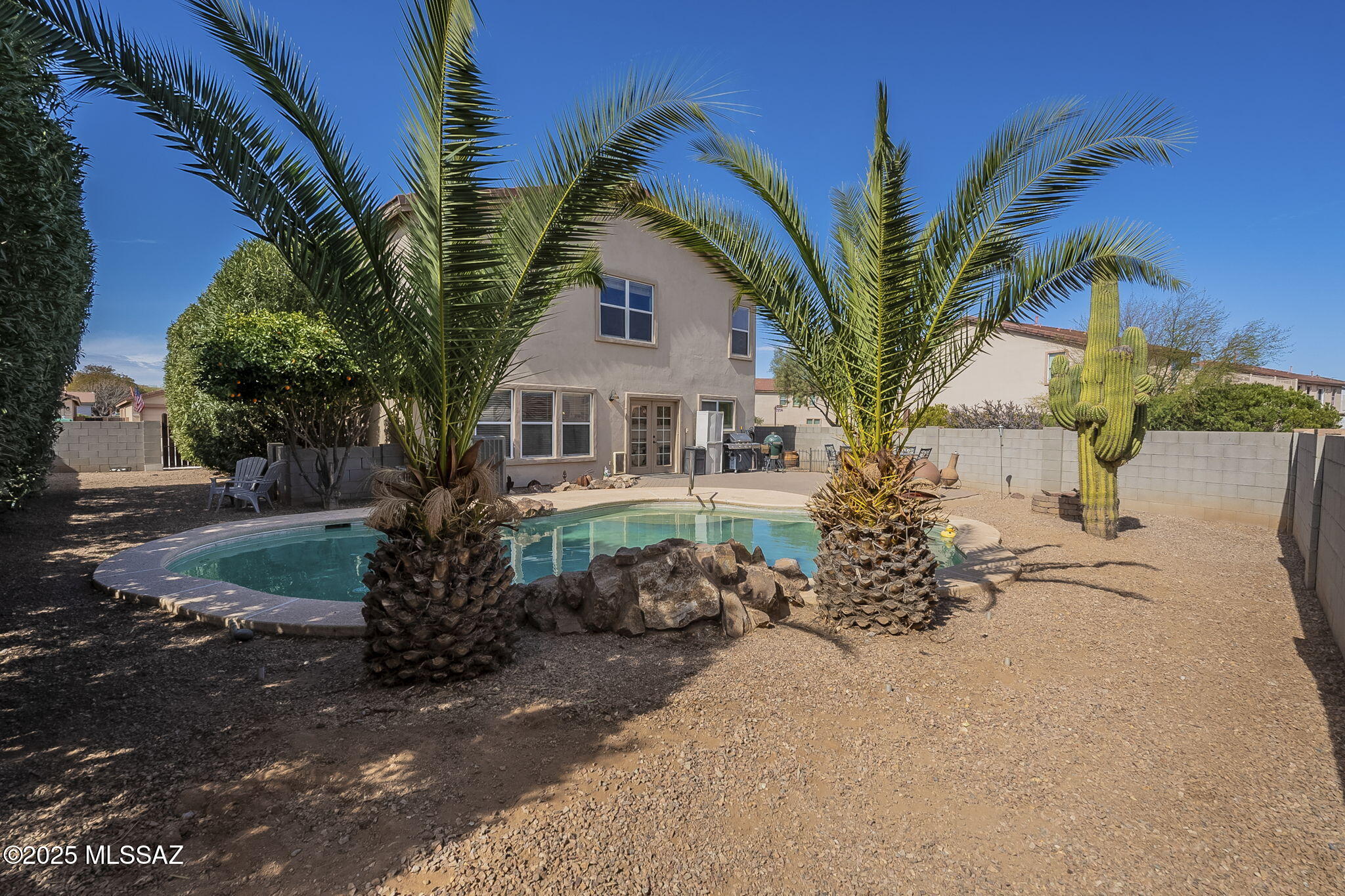 Welcome to this charming farmhouse chic home at 14693 S. Sumac Drive! Nestled in  highly sought-after community of Rancho Sahuarita, this spacious 5 bedroom + a den home offers the perfect blend of modern upgrades and rustic charm. The heart of the home is the gorgeous kitchen with stunning finishes to include oversized island with butcher block counter, stainless steel appliances, walk-in pantry, granite countertops with charming back splash and craftsman touches throughout. The kitchen opens up to the spacious family room trimmed with shiplap walls and a cozy gas rock accented fireplace. One bedroom and full bathroom is located downstairs, perfect for home office, mother-in-law quarters, etc. Travel up the beautiful wooden stairs case where the loft separates the additional 4 bedrooms. Enter into the master suite through the luxurious double doors to find a roomy and airy cottage getaway. Continuing into the bathroom you will find a grand soaking tub and separate shower, dual vanity and custom walk-in closet with loads of space. This beauty has a 2 car garage plus an additional 5 parking spots outside, yes you read that correctly! 7 parking spots in total! A very rare find in Rancho Sahuarita! Step out back to your private oasis, complete with a pool and tranquil water feature. If you want more social life, mosey down the street to visit all this vibrant community has to offer! This includes a splash pad, skate park, pool, plenty of parks, lakes, and jogging paths for outdoor fun. Rancho Sahuarita is truly a lifestyle! Don't miss the opportunity to experience this beautiful home in a fantastic neighborhood.