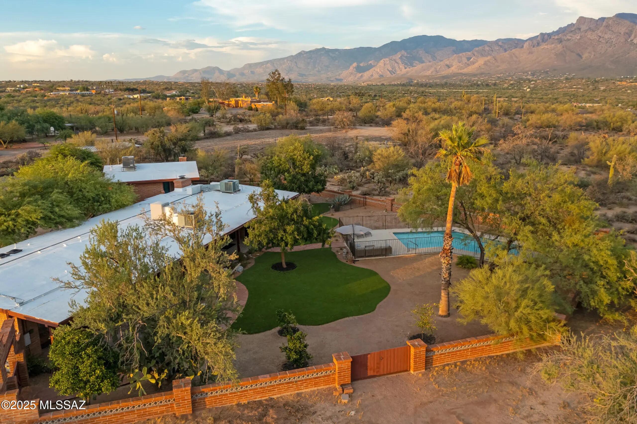 As featured on HGTV's My Lottery Dream Home!  Rancho del Plata is a newly renovated Mid-Century Modern estate that sits on 4.4 acres of pristine Sonoran Desert and features two homes: Hacienda del Plata and the Catalina Casita. The 2,576 sq ft Hacienda offers vaulted beamed ceilings, solid adobe walls, a large pool, walled yard and a spacious open floor plan. The 772 sq ft Casita features open living spaces, large bedroom, a private fenced yard, and covered patio, perfect for renting out or friends and family that are visiting. Stunning unobstructed views of the Catalina Mountains, a 1,600 sq ft garage/workshop, walking trails, and large horse corral make this property unique and versatile. Generating $86,609 in 2024 vacation rental revenue (management in place), it comes fully furnished for a turn-key investment or private desert retreat. Conveniently located less than 10 minutes from grocery stores, shops, dining, and the Tucson Loop.  No HOA.