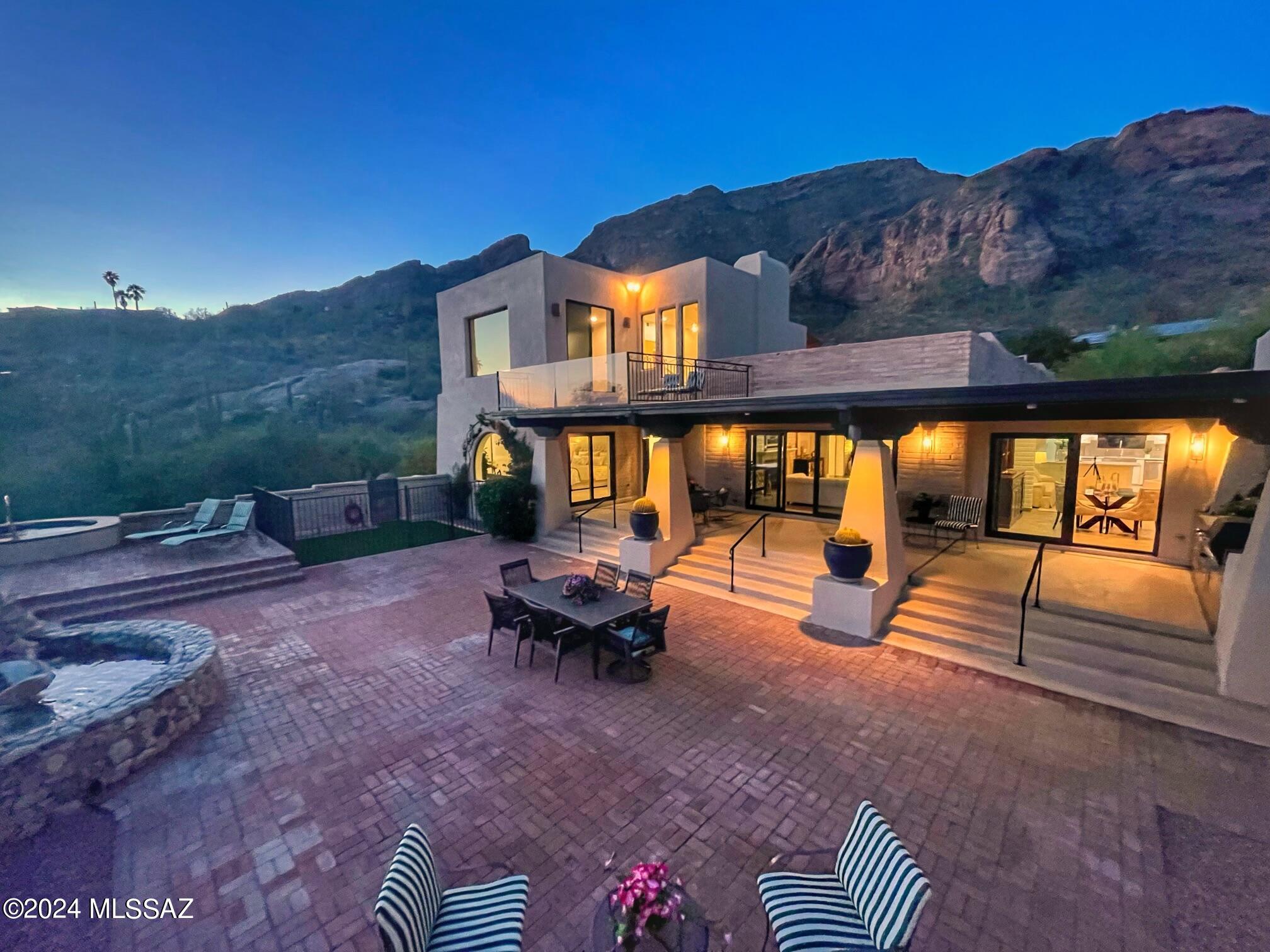 ABSOLUTELY STUNNING 4 BEDROOMS/ 4 BATHS PLUS OFFICE CLASSIC TUCSON TERRITORIAL STYLE BURNT ADOBE HOME SITTING ON A HIGH NEAR ACRE LOT OVERLOOKING SKYLINE COUNTRY CLUB, THE CITY & FOUR MOUNTAIN RANGES. ORIGINAL HOME WAS BUILT IN 1975 W/ TWO MASTER SUITES, A THIRD BEDROOM & 3 FULL BATHS. A SECOND STORY SUITE & DELUXE BATHROOM PLUS OFFICE WERE ADDED IN 2006. HOME BOASTS NEWER HIGH-END FLOORING, UPDATED KITCHEN W/ QUARTZ COUNTERS AND DOUBLE OVEN, COZY FAMILY ROOM W/ BEEHIVE FIREPLACE, INCREDIBLE ARCHED WINDOW IN DINING ROOM W/ VIEWS OF WATERFALL & MOUNTAIN BOULDERS, SPACIOUS LIVING ROOM W/ CLASSIC FIREPLACE, MANTLE, BEAMED CEILINGS & MANY GLASS DOORS OPENING UP TO A MASSIVE WRAPAROUND PATIO W/ VIEWS OF THE CITY. STEPS AWAY IS A BEAUTIFUL NEGATIVE EDGE POOL AND SPA. A VERY SPECIAL PROPERTY! UPSTAIRS ADDITION SUITE HAS A VIEW OF ENTIRE CITY AND A PRIVATE SUNNING DECK PLUS AN OFFICE WITH BALCONY FACING THE MOUNTAIN AND WATER FEATURE. TRULY AN EXCEPTIONAL HOME!