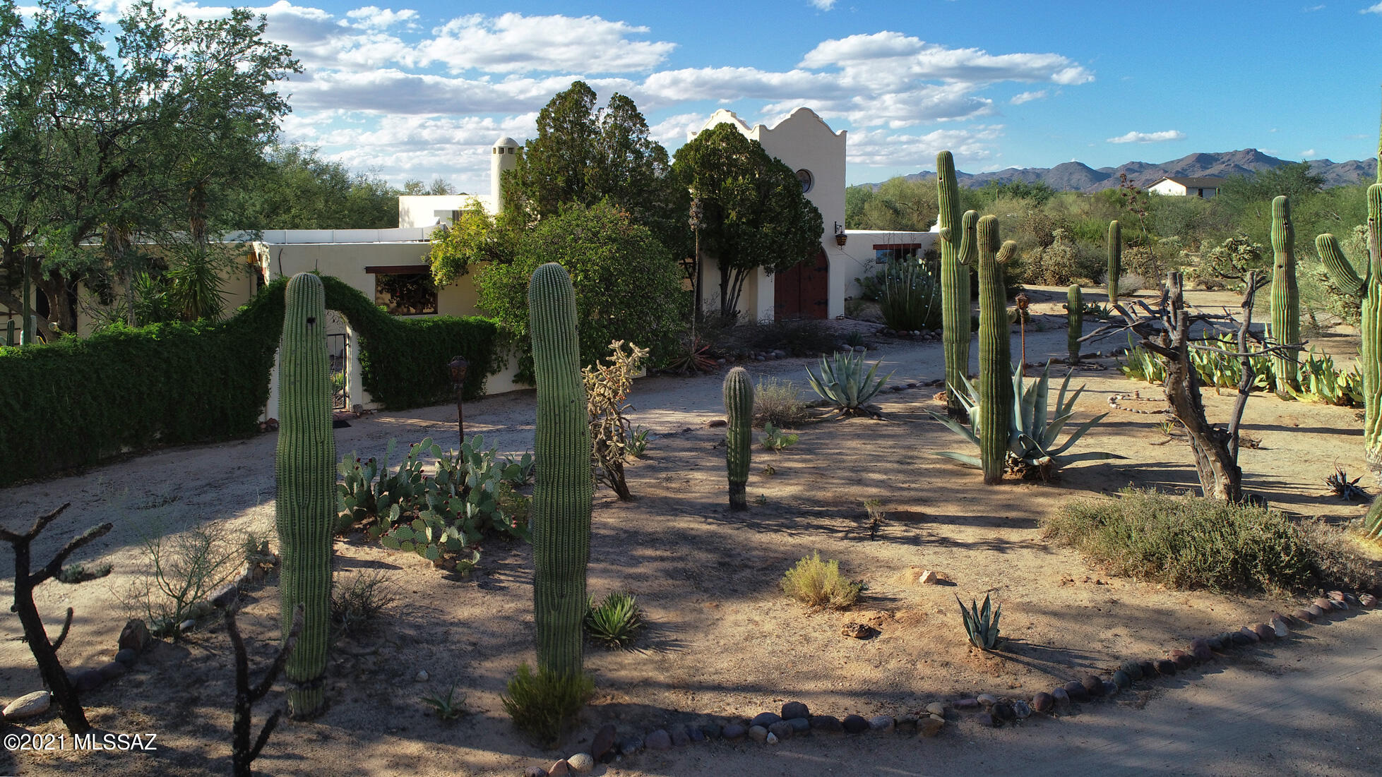 VERY PRIVATE estate features a sprawling one story Moorish Mediterranean hacienda, on a park like riparian 4.3 acre lot with 50+ saguaros, only a half a block from Oro Valley. Property features a view of Pusch Ridge & 3 mountain ranges, sparkling pool, lush courtyard with Koi pond and bubbling fountain, labyrinth, pecan wood floors, hand carved mesquite doors and artisan architectural features throughout. Huge rooms with loads of big windows to view the abundant wildlife. 12 rooms total (that are flex-space), including guest quarters with private entrances. Great for AIRBNB, multi-generational family or home/work situation. Level topography with loads of trees and a nature trail. Horse & animal friendly. 5 minutes to shopping/restaurants/golf. Seller will review all offers on Tues. 10/19.
