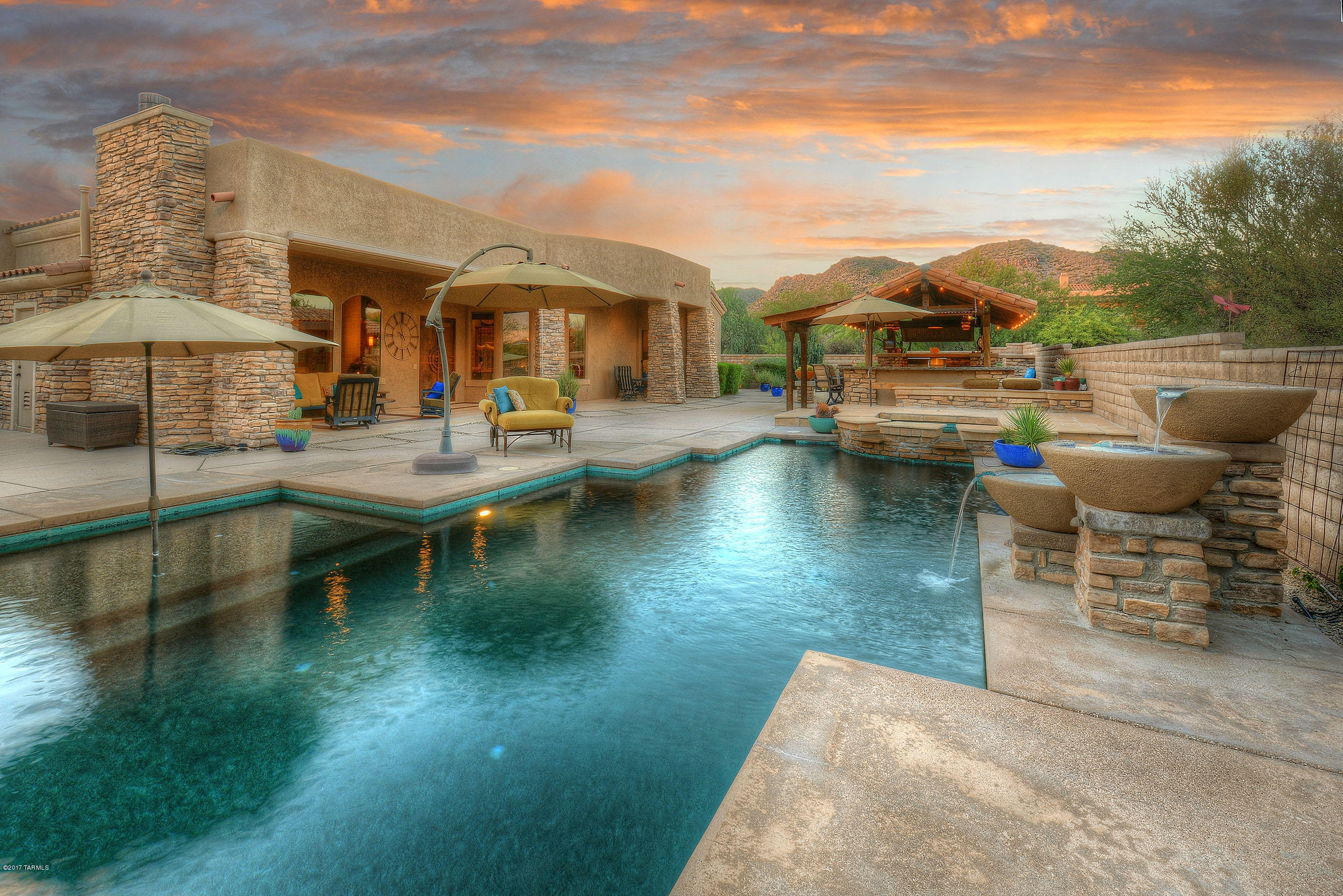 UNIQUE DESIGN THAT INFUSES RUSTIC W/ MODERN ELEMENTS...CREATES BRILLIANT RESULTS! NOT YOUR TYPICAL SW CONTEMPORARY- THE MERGER OF CLEAN  LINES BLENDED W/FLAVOR OF A MONTANA MTN RANCH!EXQUISITE FINISHES INCL ALL NATURAL STONE, ROUGH SAWED TIMBERS/BEAMS,RECLAIMED WOOD UNITE TO MAKE THIS ''ONE OF A KIND HOME''! AMAZING BACKYARD- ENTERTAINING DELIGHT! CUSTOM DESIGNED OUTDOOR FULL KITCHEN- BELONGS ON FOOD NETWORK! EQUIPPED W/ALL COMMERCIAL SS APPLIC/BBQ, COOKTOP/REFRI,ETC...TO MAKE YOUR ALFRESCO COOKING/DINING A TRUE EXPERIENCE! PLENTY OF PATIO SPACE,  RELAXING LOUNGE AREA W/TOWERING RUSTIC STONE FP, SPARKLING SOLAR POOL/SPA- EVEN YOUR OWN OUTDOOR SHOWER!UPGRADES FILL THIS ESTATE~ ALL EN-SUITE BR'S,MEDIA/FLEX ROOM, SEPERATE GUEST WING, 4 CAR/+EXTRA STORAGE RM, GRANITE/TRAVERTINE THRU-OUT...