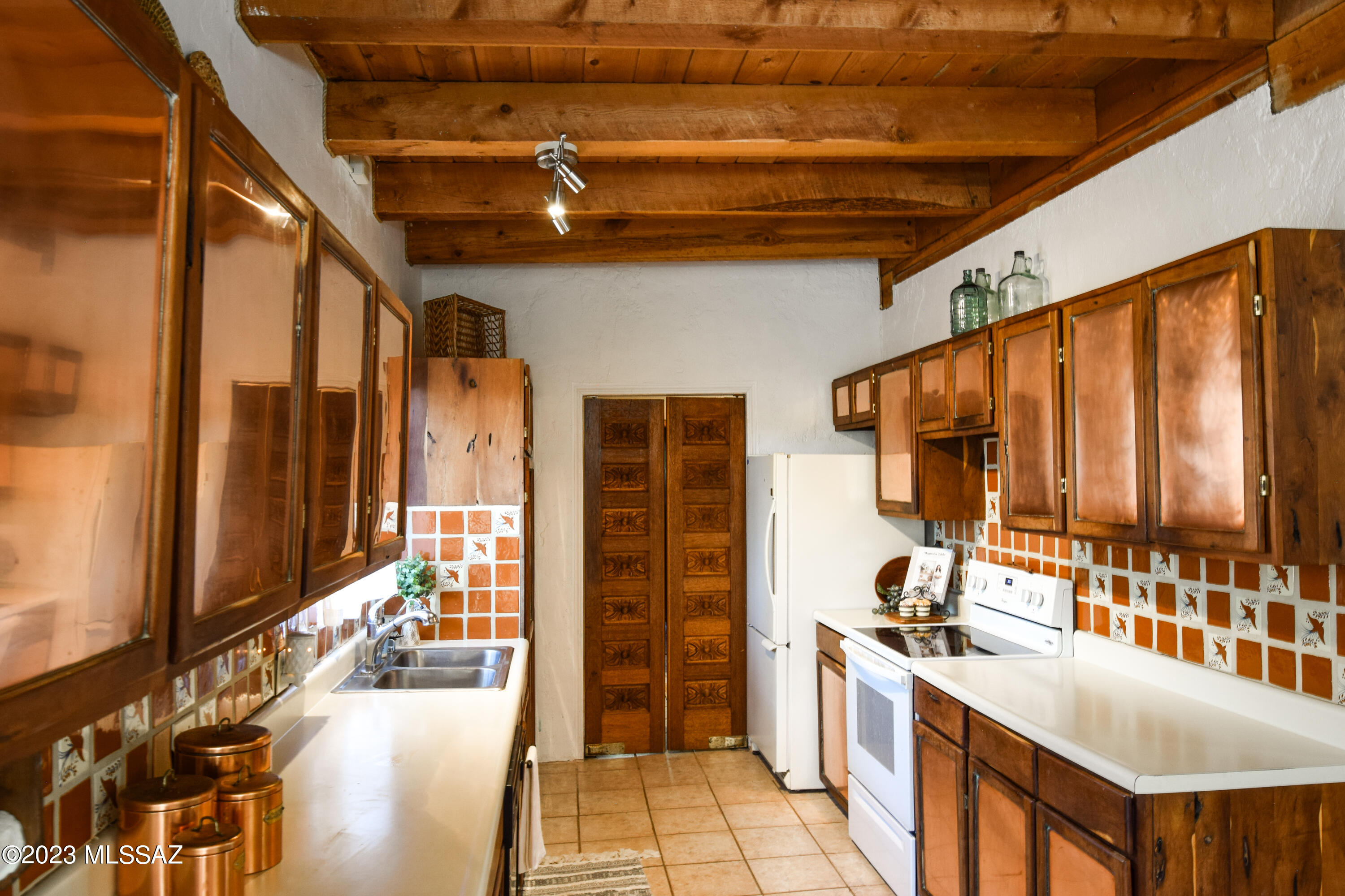 Lush homestead with a pond! Large family home has owned solar panels, mini splits throughout, a wood stove & stuccoed solid block construction making it extremely energy efficient! Galley style kitchen lined in mesquite cabinets inlayed with shining copper. Hand carved doors lead to oversized laundry/storage room. Beautifully stained concrete and saltillo tile flooring throughout & naturally beautiful ceilings. South facing AZ room gets plenty of sun making it perfect for the garden starter. Multiple rainwater catch tanks surround the home & garden beds are ready. Outside, a secure courtyard for pets & kids, 3 carports, & play set are a few perks. Well is connected to electric but could be converted back to the windmill. Acreage is fenced, has water lines & a storage building.
