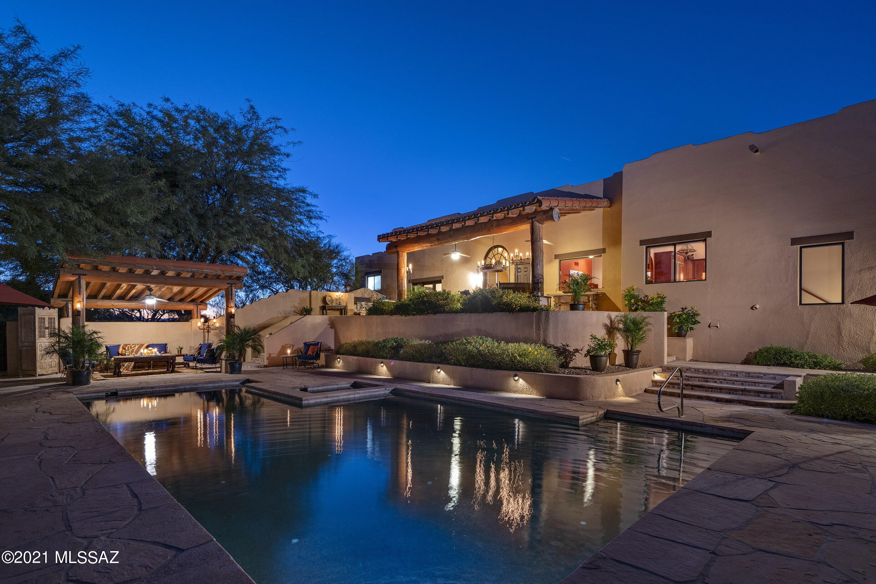Situated on a commanding 1.07 acre hilltop, with unobstructed city and mountain views stretching out over the valley below, with the Catalina mountains creating the perfect backdrop from which this homesite was selected. Maximizing the home's dramatic relationship between interior and exterior spaces is achieved through careful design and placement of structure, with connectivity to the surrounding landscape. Exterior transitional spaces are rich in mobility with the capacity to enjoy and entertain being effortless, emphasizing views that extend through the interior and outdoor living spaces. Upon entry, you are greeted by a large foyer acting as the central hall, with the informal living room elevated on the East end of the residence... ...with large picture windows allowing natural light to fill the space, flanking the kitchen and formal living rooms, establishing the main connection point of the home. The private West wing features the sumptuously appointed primary suite, with dual walk-in dressing closets, a large shower and soaking tub with Talavera tile surround. 

The floor plan comprises both formal and informal living spaces, equally suited for scaled entertaining, as well as quiet moments, with a chef's kitchen that boasts a large center island, custom cabinetry, ample storage and functional counter space, with every measurement and detail having been carefully considered to enhance the user experience.

Seamless indoor-outdoor entertaining while out on the sun-drenched South facing terrace, offers al fresco dining, with a dedicated built in barbecue station, dining pavilion and a series of patios and exterior living spaces that create a succession of courtyards resulting in varied focal points. The outdoors unwind like a garden narrative of texture, light and mood, with every comfort having been considered and detail meticulously crafted, the result being a home that offers a sense of ease to enjoy the Arizona Lifestyle.