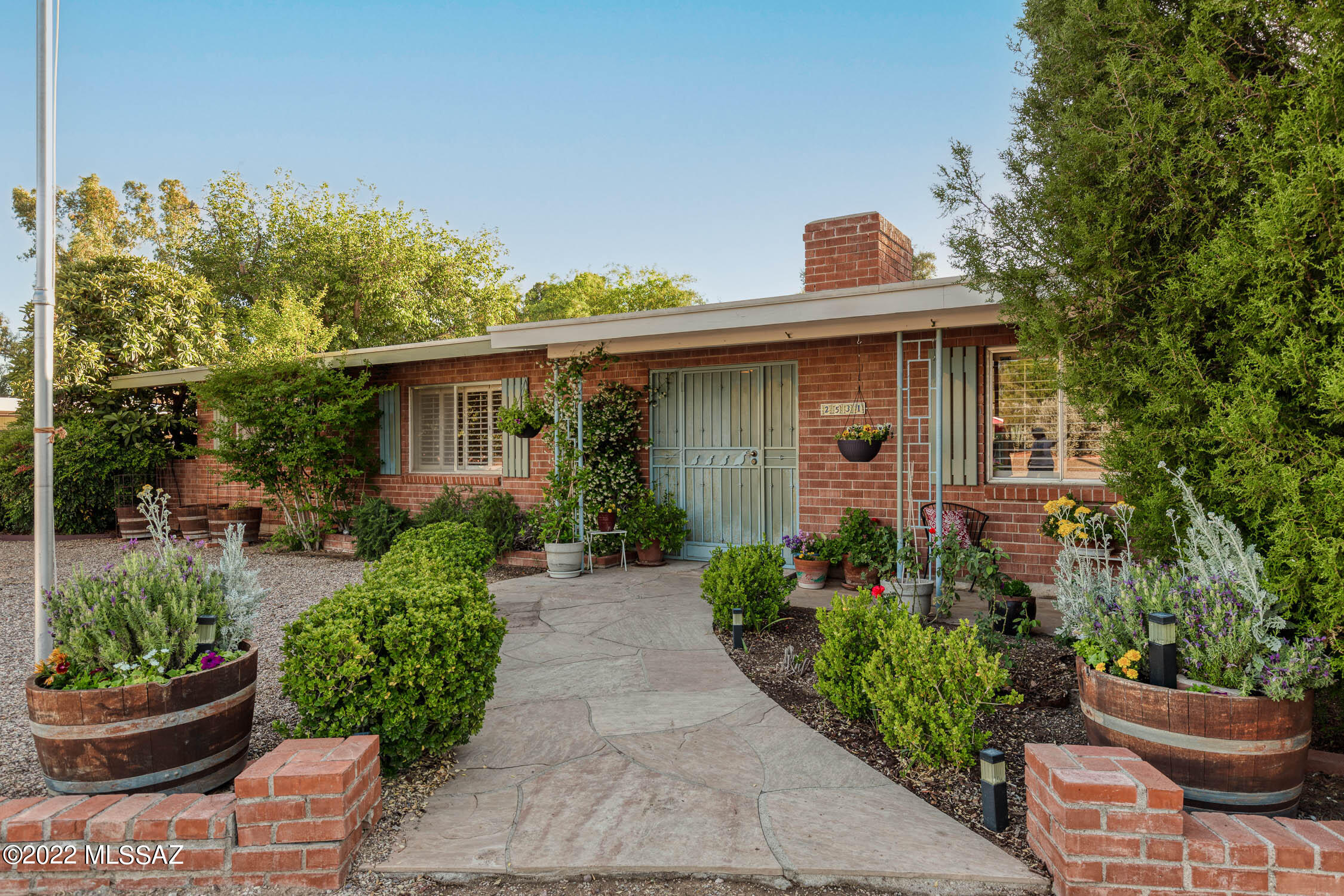 Enjoy the prestigious Tucson Country Club lifestyle in this well-preserved 1960s brick home with a single owner! A gemstone waiting to be polished! Situated on a spacious .72-acre lot and on the ''quietest street in the neighborhood'', surround yourself with spectacular mountain views in this sought after gated neighborhood. The private backyard oasis includes an expansive covered patio, lush green grass, and extended brick paving. Generous-sized living and family rooms each with a cozy fireplace for those chilly winter evenings. The kitchen boasts vintage charm with a bright skylight, plenty of cabinet space, SS appliances, and a breakfast bar. Formal dining room with sliding doors to backyard. Spacious master suite boasts a generous sized closet, ensuite bath, and backyard access. Attached guest quarters complete with private entrance, kitchenette (no stove), living room, and a separate bedroom. Fantastic space for an office or in-law suite. Located within minutes of "The Loop" with easy access to golf, hiking, restaurants, and shopping. Don't miss your chance to join the active Tucson Country Club Estates and turn this home into your dream!