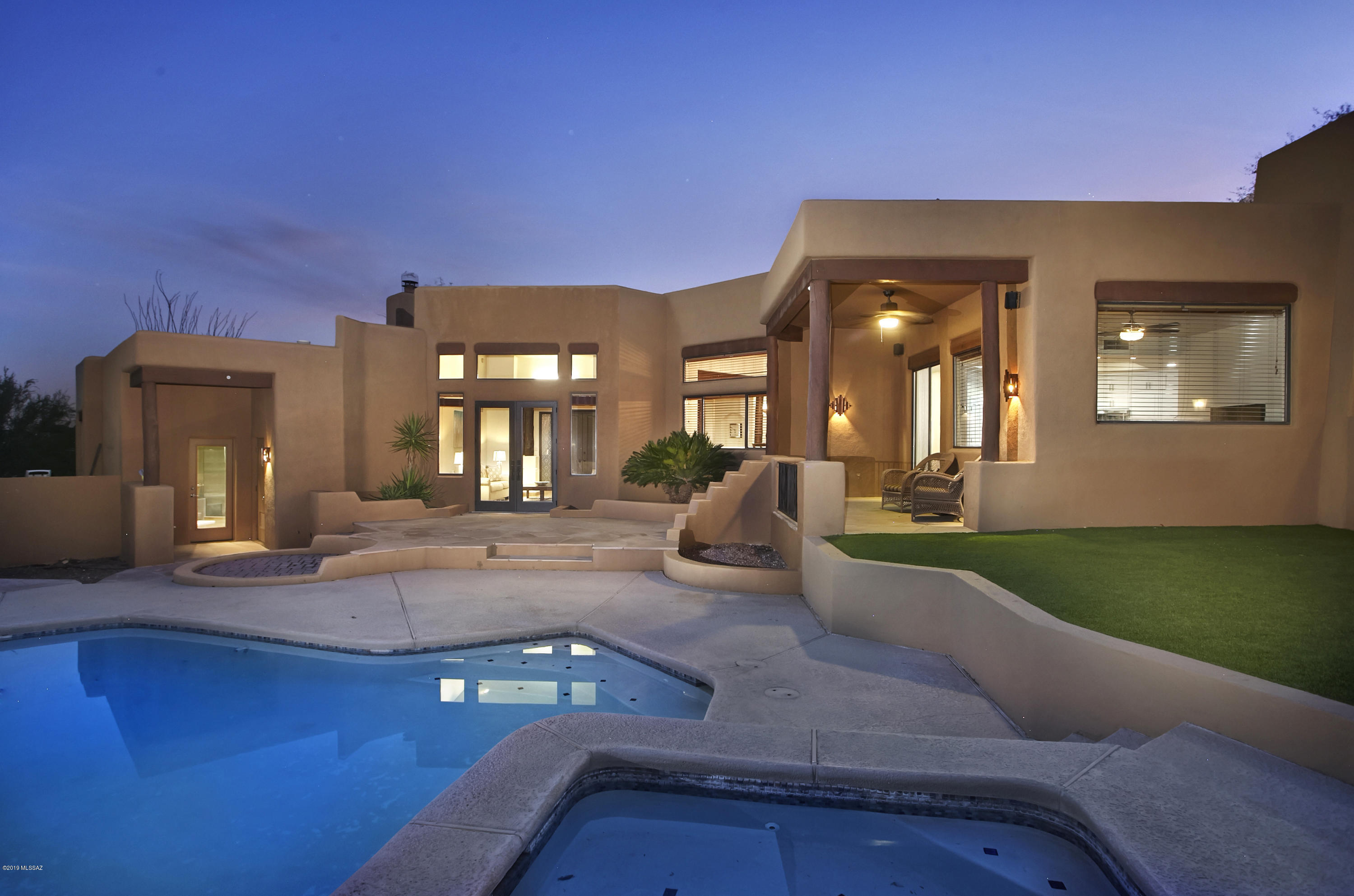 Nestled securely behind the manned gates of Hacienda del Sol Est, sits this beautifully updated soft desert contemporary home. Updates include a stunning new designer kitchen w/timeless white cabinets, prep island, granite countertops & stainless appliances, travertine tile floors throughout & updated bathrooms. Relax in the master suite w/stacked stone gas fireplace, jacuzzi tub, large shower & walk-in closet. The high ceilings & vega beam accents accentuate the open floorplan & walls of windows frame the inviting backyard w/artificial turf & sparkling pool/spa. The majestic Catalina Mtns towering overhead provide an unobstructed view of Finger Rock & ideal backdrop for outdoor entertaining on the terrace. Oversized 2 car garage, Low maintenance landscaping & convenient Foothills location