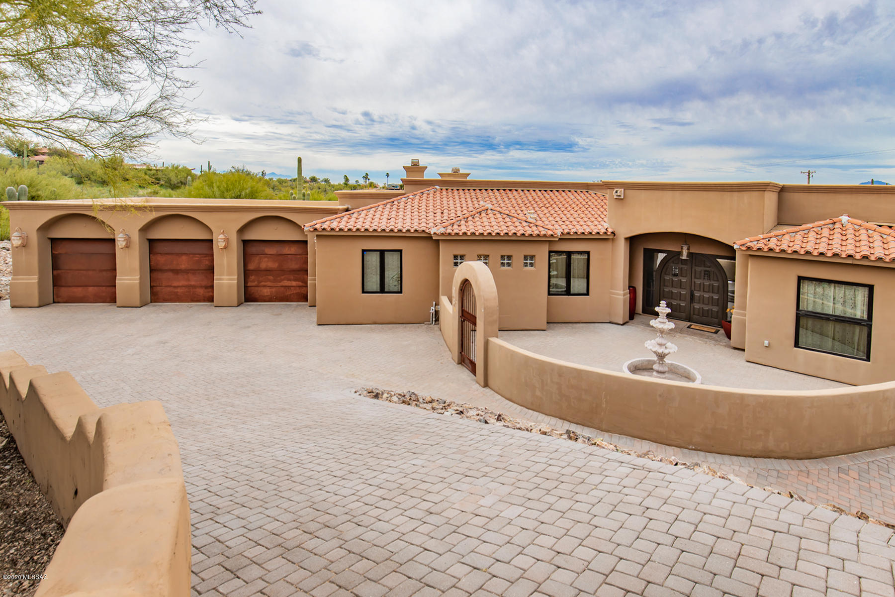 Spectacular Mediterranean crafted w/high end finishes & products, designed for everyday living & entertaining. Colored, scored concrete floors are found throughout w/walls of dramatically oversized windows & doors bringing the light & city views in. The ceilings are amazing, offering domed, coved, coffered & barrel vaulted treatments. Cantera stone columns & fireplace surrounds add character & old world charm. The chef's dream kitchen boasts built-in coffee center, butler's pantry w/wine frig & professional 6-burner gas range to name a few. Luxurious master suite enjoys romantic fireplace, custom cabinetry his & hers walk-in closets, a walk thru shower w/dual heads & large jetted tub. Enjoy the city lights in comfort from the wraparound covered patio. One-of-a kind home, not to be missed