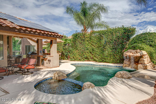 Beautiful 2 Bedroom, 2 Bath house w/a den, living room, dining room, family room & an OWNED solar system (low electric bills!). The private backyard is an oasis w/a relaxing pool/spa, waterfall, outdoor kitchen w/built-in table w/seating for 8, BBQ, cocktail station & fridge. The Master Suite has 3 closets, & the Master Bath has a walk-in, door-less shower w/stone flooring, vanity w/vessel sinks, oil-rubbed bronze fixtures, tile counters & back-splash. Private Guest suite. Guest Bath has tile & a copper sink. The upgraded kitchen has stainless appliances, smooth-top elec. stove, micro, dishwasher, R/O & granite counters. The living room area has a bar area w/a built-in wine cooler. The Den has eng. wood flooring & faux copper/tin ceiling. Tile flooring in all the living areas,  Bedrooms have carpet (new in 2014). 2 Car Garage w/epoxy flooring & Built-in Cabinets & separate Golf Cart Garage w/lots of cabinets for storage. New water heater (2014), Soft-water loop. NO CFD tax. View this house and make it your home today! Most furnishings available with a SBOS.