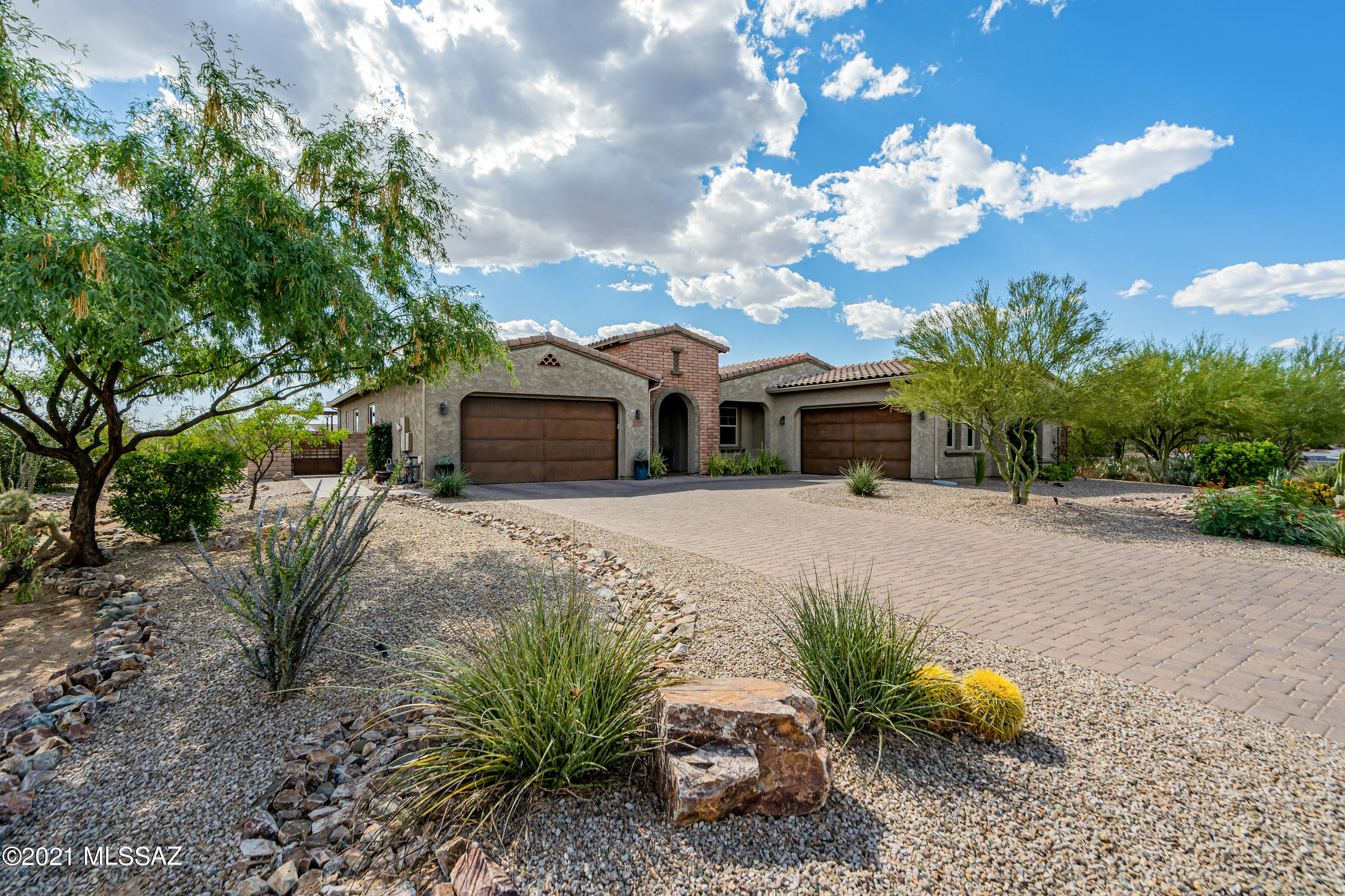 Your search stops here with this exquisite home located in the desirable gated community of Rancho Del Cobre. Open the stunning iron entry door to find a rare 5 bedroom home with  a den and 4 car garage. Dream kitchen boasts double ovens, granite counters, stainless appliances, gas cooktop, chic backsplash and a generous island. Home also features dramatic 8 ft doors, 10 ft ceilings, plantation shutters, rectangular tile flooring, surround sound and on-trend lighting. Spa-like owner's suite has a large soaking tub, separate shower and dual vanities. Step out to the resort style backyard which backs to open space for privacy and VIEWS. Featuring a refreshing pool with travertine deck, gas fireplace, outdoor kitchen under a pergola, easy-care artificial grass. A truly spectacular find!