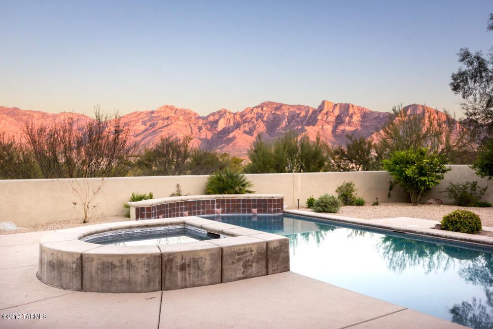 Absolutely stunning custom home on 1.18 acres overlooking the beautiful Catalina Mountains in this private one of a kind neighborhood. This house has everything! Limestone flooring, Gourmet Kitchen with Granite, Upgraded Appliances, Wine Fridge and Custom Cabinets. All the bedrooms have their own bathroom with custom Travertine accents. Enjoy the private resort style outdoor living with the sparkling pool, spa, built in BBQ and unobstructed Catalina Mountain Views with no one behind. This floorplan is one of the best I've seen. This home is a must see! Upgrade list under documents.