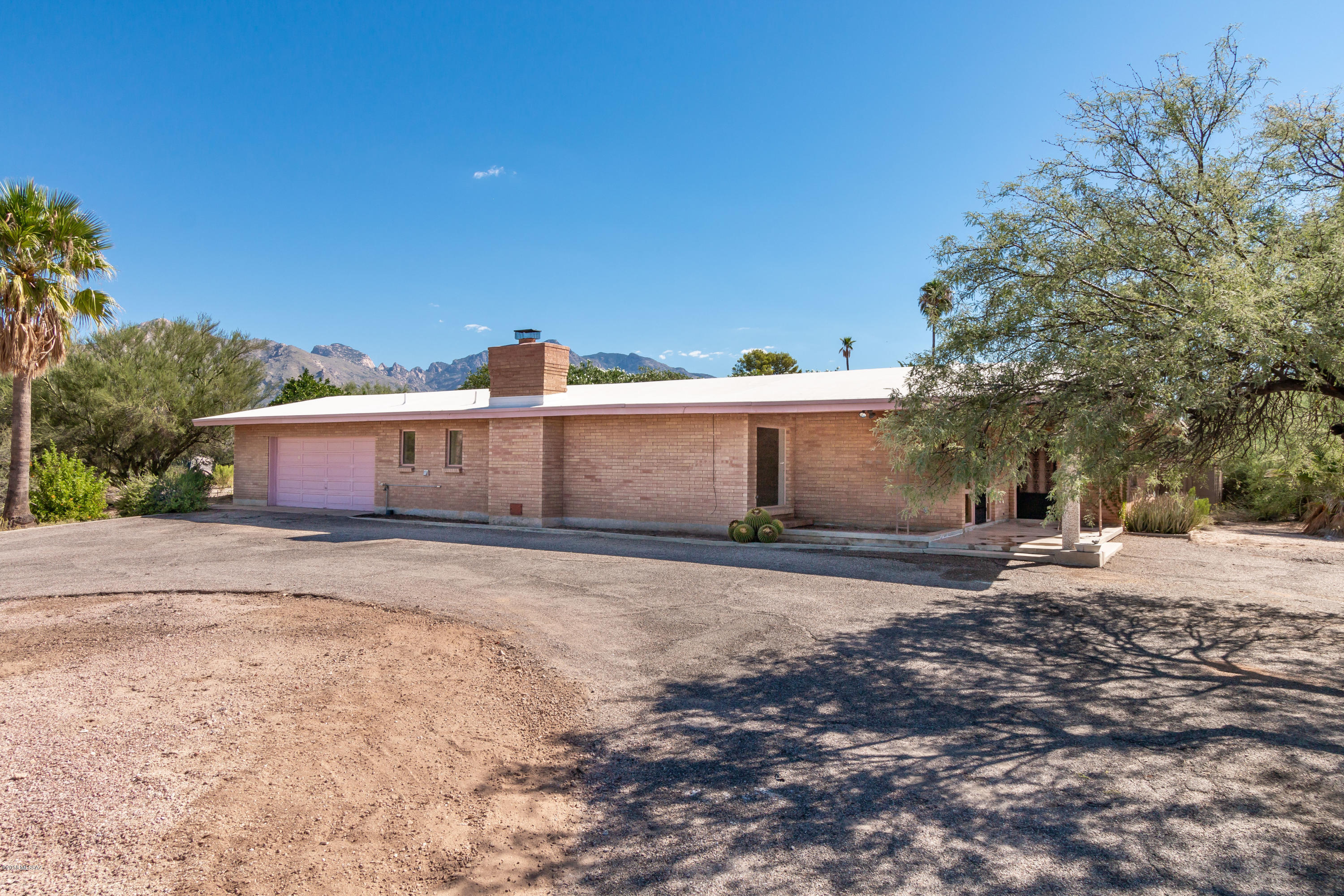 Priced to sell! Rare opportunity to buy a charming 1962 double-brick ranch house in Casas Adobes on almost an acre of land, with large swimming pool, private backyard for gardening and covered back patios for entertaining, citrus orchard, and views of the Santa Catalina Mountains. House has a cool Mid Century vibe and just needs a push in the right direction!  Renovation of Master Suite (bedroom, bathroom, walk-in closet, laundry room) started, but not finished providing you the opportunity to get this property at below market price and make this your own. All new bathroom fixtures including free-standing soaker tub, cabinets, sinks and countertops, faucets, toilet, ceiling fans included in sale of home.