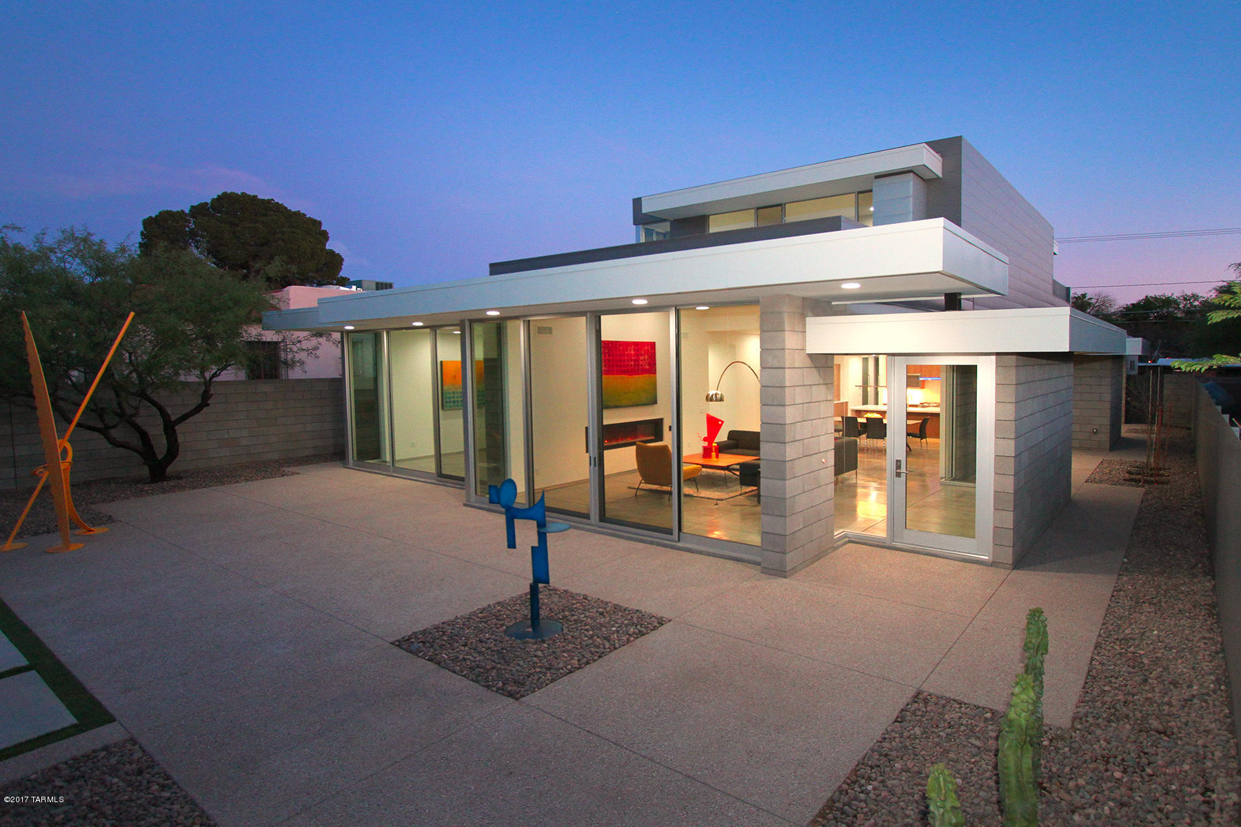 Totally UNIQUE OPPORTUNITY – NEW contemporary home in SAM HUGHES designed/built by Donald Kornberg. Sleek & spacious design while taking in the abundance of light from flr to clg 10' windows & sliding doors opening to the outdoors. Very PRIVATE and SECURE on ELEVATED LOT w/ walled in yard. ARCHITECTURAL masonry & metal shell & EXPOSED CONCRETE FLOORS for easy care. Great rm concept with separate DEN/media rm, mst suite & 2nd bedrm/office on the 1st flr, 2 bedrms, bath & ROOF DECK upstairs. Kitchen has flipper glass doors, GAS STOVE,  PANTRY, includes ref. GLASS BARN DOORS @ mst bath, designer tub, dbl sinks, walk-in closet, in-line shower drain. ELECTRIC LINEAR FIRE PLACE, 3 zone HVAC, 3 car-garage plus 1 pkg space. Walking distance to UofA, Himmel Park, Rincon Mkt & Close to downtown