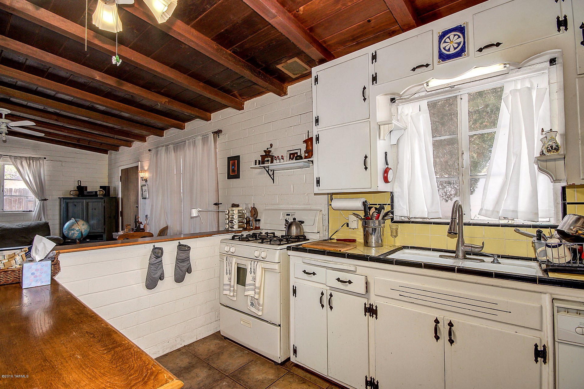Cozy Home full of Character and Charm. Vaulted wood beamed ceilings, crisp interior palette, ceiling fans, carpet & tile flooring. Retro kitchen features white appliances and white wood cabinetry with hardware. Large window for lots of natural light. Vintage bathroom with tile. Huge backyard for your future desert Oasis. Covered patio, storage shed, walking paths, shade trees, and Mountain Views. Do not miss this ''gem'' in the desert!