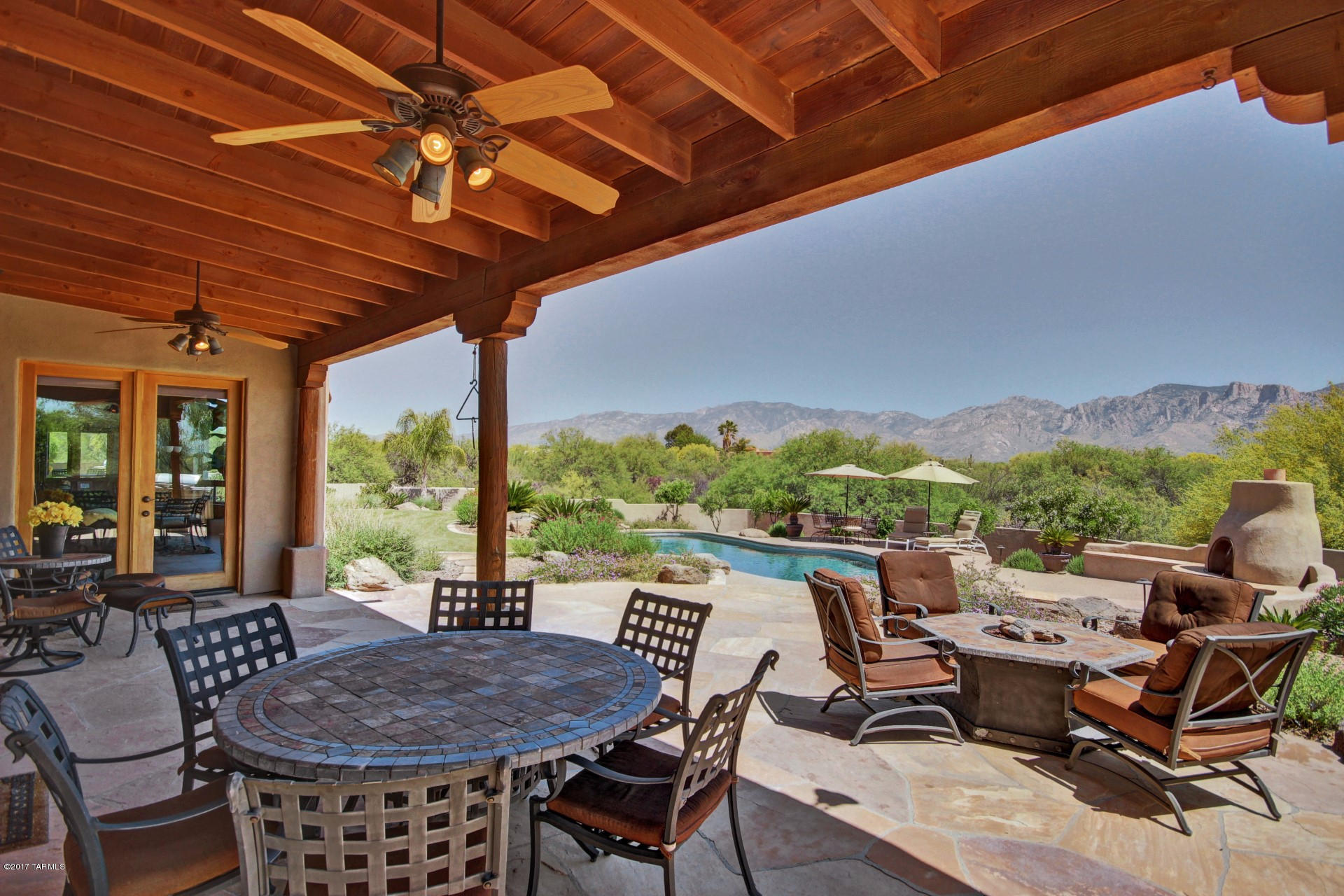 MAGNIFICENT home surrounded by breathtaking Mountain & Sunset views with a charming private gated courtyard entry boasts endless upgrades & specialty features. Soaring ceilings, French doors, upgraded lighting/ceiling fans, 2 electric fireplaces, wood beam ceiling in great room, built-in media shelves, & beautiful tile floor. Granite counters, breakfast bar, 2nd center island, tiled backsplash, SS appliances, pantry & wood cabinetry. Built-in cabinets in formal dining room. Stunning Catalina Mountain views from Den, Master Bedroom, & Great Room. Master BR features 3 large closets and a designer style bathroom. Ample storage, cabinets, & workspace in the 3 car garage. Premium sound system inside & out. 5 parcels share well. Be sure to see DRONE FOOTAGE! OWNED solar system is for pool on