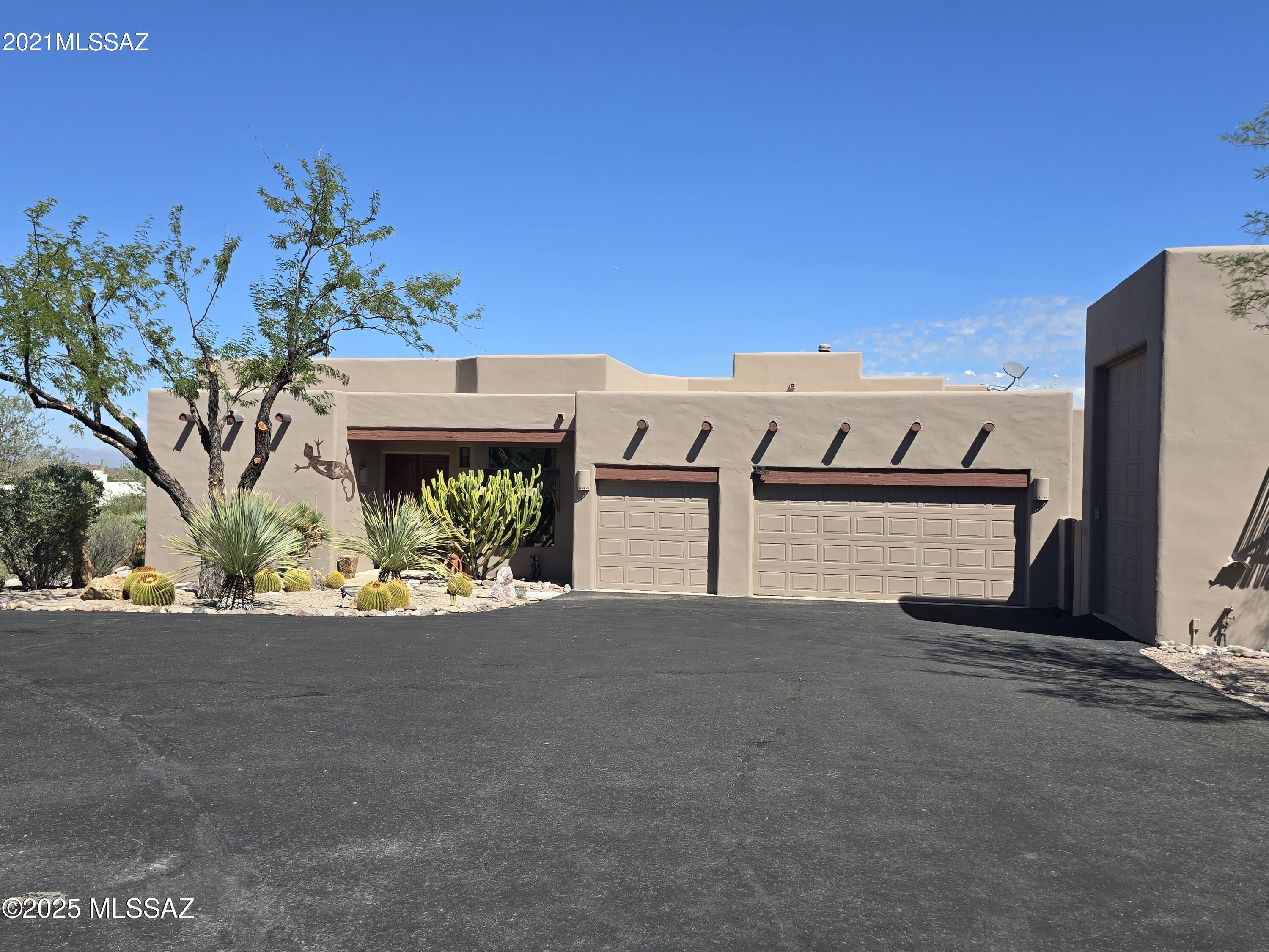 Classic Sante Fe style home on an acre! Mountain and city views! 4BR/2.5BA with an attached 3 car garage and a separate 24' RV garage with hookups! Recently had exterior painted, roof coated, driveway recoated, primary bathroom remodeled, kitchen cabinets redone, newer tankless water heater. Enjoy 2 covered patios for eastern shaded evenings overlooking the lush landscaped yard/pool/spa with no rear neighbors and desert and city views! All furnishings included in sale, even the safe. Solar lease has been paid off! Enjoy low TEP bills until 2035! Fridge, washer/dryer all convey. HOA is now inactive. Has a termite warranty!