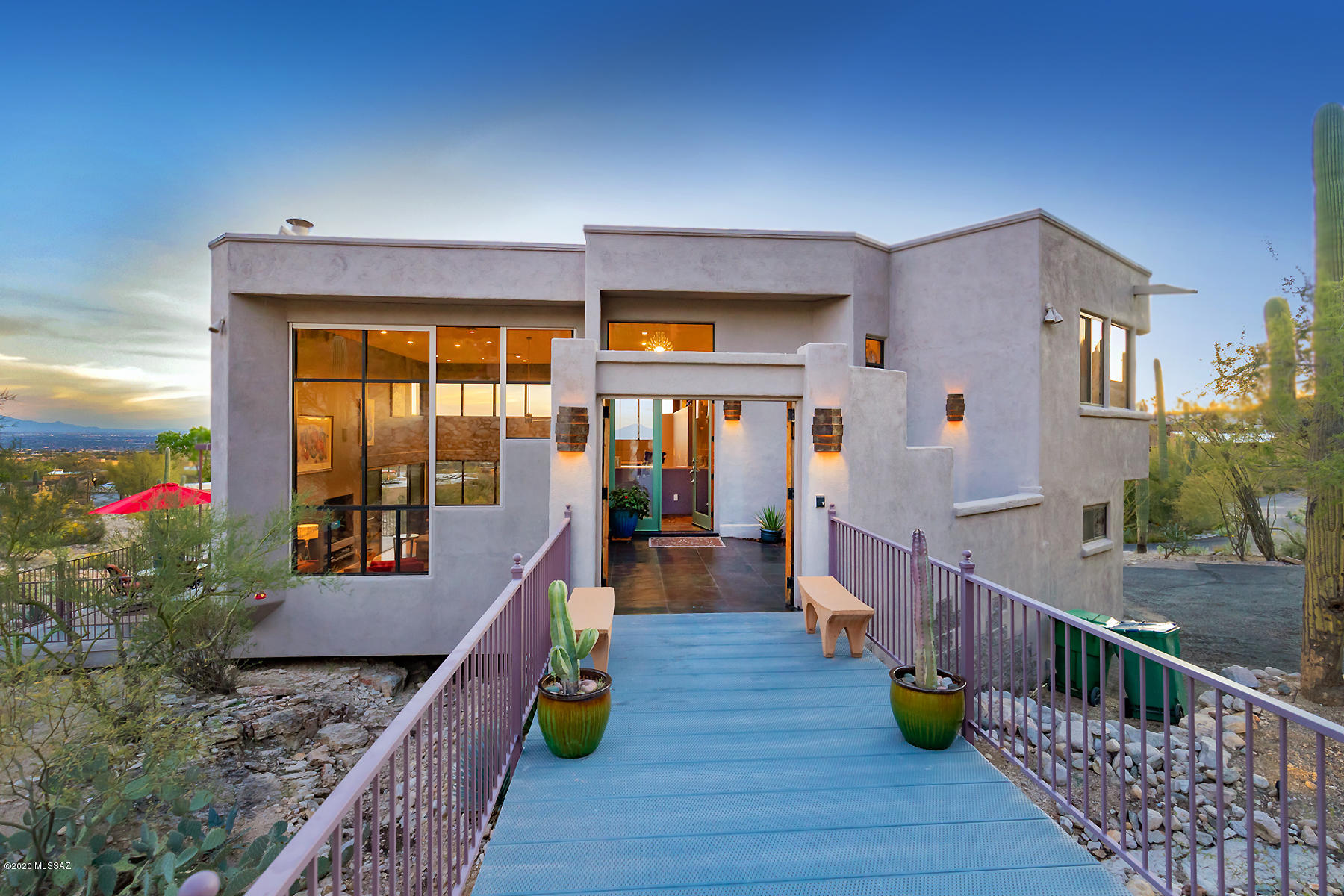 Forever views of the city & Coronado National Forest! Discover walls of windows in every direction, leading to spectacular rare & unique setting inside & out! All windows feature rolling shutters perfect for locking up & traveling! You will also fall in love this luxury contemporary home featuring a grand metal bridge entrance w/plenty of parking for guests, stunning great rm w/20 ft high ceilings! Cooks will enjoy the granite kitchen w/cherry cabinets, granite, hi-end appliances wet bar & laptop desk! Double sided gas FP, pool table/game area & spacious dining area-all opening to 2400 square ft of 3 luxury patios w/captivating city lights & mtn views! Enticing master ste w/spacious lounge area, spa tub w/FP & private viewing patio! 2 guest/children BR's/offices!