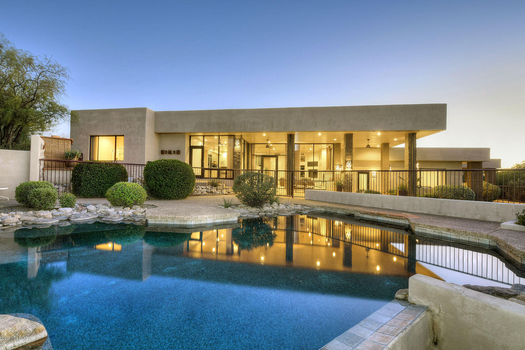 Stunning 5 bedroom, 4997 sq. ft. contemporary designed & built by New West Design Studio, high on a hill in prestigious, gated La Paloma Estates with sweeping Catalina Mountain views.  Enter into living room/dining room with beautiful quartzite floors, exposed split-face block walls, walls of windows, two-way fireplace and wood planked ceiling.  Kitchen/family room combination features breakfast area, granite counters, center-island with breakfast bar, designer appliances, fireplace, entertainment wall and views, views, views! Gracious master suite offers fireplace, private patio, walk-in closet and dual vanities.  Wonderful back yard designed by John Stropko with covered porch has pool, spa, BBQ, outdoor fireplace with bancos and large grassed area with putting green.