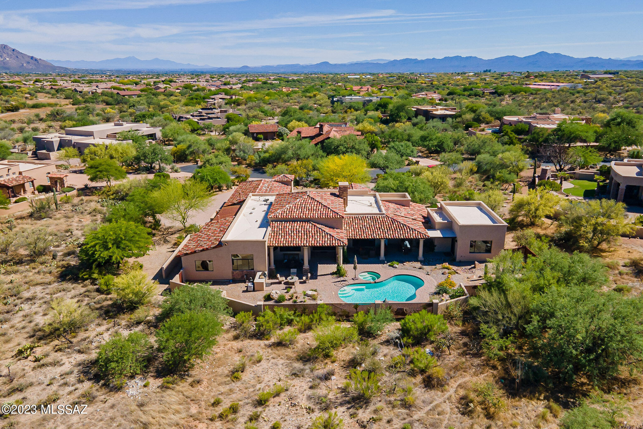 Privacy, serenity, seclusion, quality and timeless design on a cul-de-sac in guard-gated prestigious Stone Canyon, a welcoming community featuring Arizona's' top-rated golf course, fabulous activities and an excellent Club dining experience offering curated menus and wine tasting evenings for many occasions. This desert home is perfect for enjoying the casual yet sophisticated lifestyle found in Stone Canyon.  Be enchanted as you enter this Tuscan-contemporary masterpiece through a luxuriously landscaped courtyard and the handsome custom iron and glass double doors. Well-balanced luxurious finishes enhance the easy flow of interior and exterior spaces, with attention to detail as shown in the extensive list of Distinctive Features. Tumbled travertine and pecan wood flooring, a chef's kitchen providing two large pantries and the finest of appliances, a casita/ exercise room, salt-water pool with built-in cleaning, these are just the beginning of the list!
The great room provides plenty of space to relax, with soaring ceilings and a stunning linear fireplace surrounded in floor-to-ceiling black granite that handsomely contrasts with the alderwood cabinetry and rich travertine flooring. A cozy dining alcove with coffered ceiling is adjacent, overlooking the pool. The heart of the home is the glorious Chef's kitchen, with custom richly hued cabinetry, Taj Mahal quartzite countertops, top-end appliances including a Sub-Zero refrigerator, French café door oven, warming drawer, 48" Wolf cooktop with two additional ovens and TWO huge walk-in well-designed pantries...plenty of space for the seldom used turkey roaster, stock pot, slow cooker and Instapot! A custom-tailored island offers an array of counter space and generous sitting area, acting as a focal point in this fabulous kitchen. The delightful shaded breakfast patio is just outside the kitchen. An elegant walk-in wet bar includes a sub-Zero wine refrigerator and ice maker. The nearby powder room focuses on an elegant vessel sink and custom faucet.
The owner's suite is sumptuously appointed, with doors leading to the covered terrace and pool. A spacious bath area showcases a steam shower, Jacuzzi tub and an oversized walk-in closet with fabulous California Closets-style built-ins. Adjacent is the spacious casita, a perfect space for an exercise area, or easily closed off for a private casita with built-in under-counter refrigerator, access to the rear terrace, and with a private entrance through a lovely small courtyard. Two additional bedrooms are ample, with en-suite baths and well-fitted closets. The office looks out to Tortolita Mountain views, with doors leading to the shaded terrace & pool. 
The outdoor oasis features wrap-around covered terrace space accommodating multiple dining and gathering spaces, delightful for entertaining or just relaxing by (or in!) the pool and spa and enjoying views of the Tortolita Mountains and Arizona's famed sunsets. A built-in stainless barbecue is nearby. The oversized 3-car garage has epoxy finished floors, room for extra refrigerator, storage room and handsome metal doors. A huge beautifully finished laundry room, with stunning granite counters, built-in ironing board, more handsome cabinetry and large stainless sink, is nearby. Enjoy the resort lifestyle in Stone Canyon, conveniently located near all desired amenities in beautiful Oro Valley!