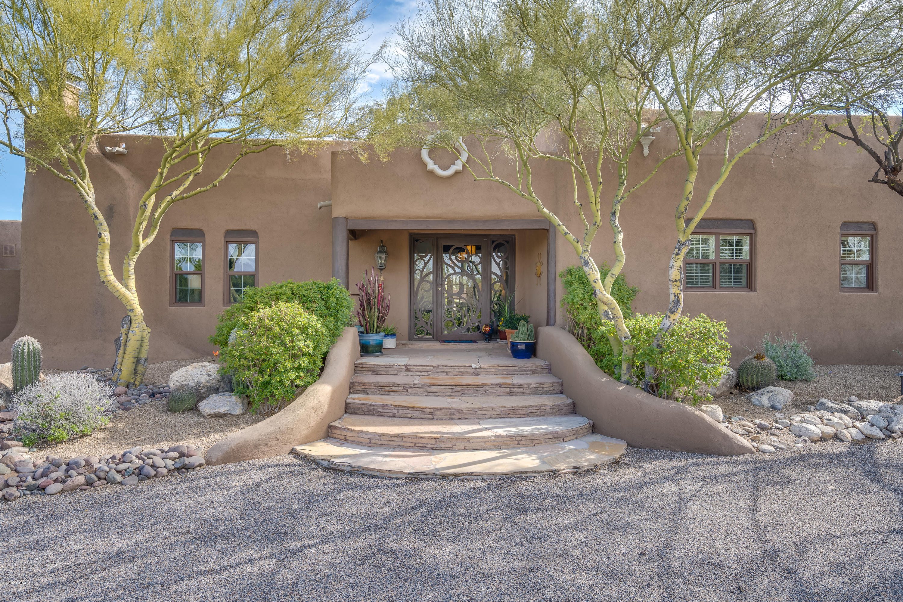 Welcome to true serenity in the middle of the City!! This magnificent Santa Fe Home situated on over 2 acres of horse property lot offers 3,853 SF, 5 Bedrooms w/optional 6th bedroom, 3 full bathrooms w/3.5 car garage. One of the suites can be used as guest quarter with its own living room & entry to the rear yard. Amazing Catalina Mountain Views from the rear yard with your personal oasis, fire pit & plenty of covered areas to entertain your family and guests. Beautiful stained concrete flooring thru out the entire house with exposed vigas beams to truly enhance the AZ  Santa Fe Home. Spacious Kitchen with double oven, 2 dishwashers, wine coolers, island gas stove, wet bars, & many more. Heated pool for you to take advantage of it all year long & newly installed tankless water heater for the master suite. Come & visit today to truly experience the Santa Fe living in Arizona!