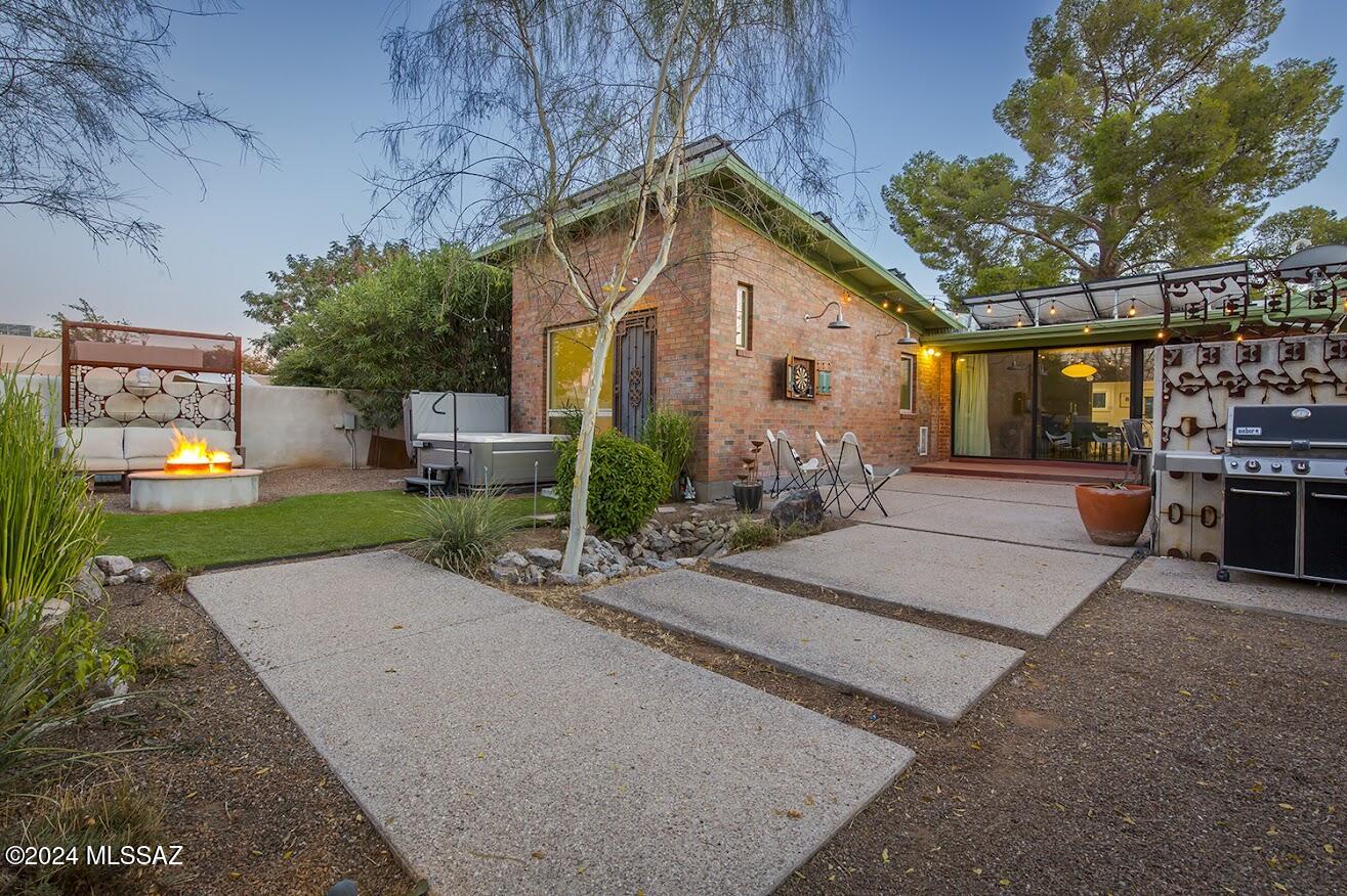 Just reduced! Gorgeous midcentury home in desirable Catalina Vista historic neighborhood, with stunningly remodeled kitchen, lovely modern design, beautiful finishes.  Living room features a built-in bar and wine fridge, and sparkling floor to ceiling new windows to the back patio and yard.  Patios have been opened up for outdoor entertaining!  Primary bedroom and bath addition make this a spacious home; addition is brick, matching the rest of the home seamlessly. Baths are exquisite and modern, laundry was just completed this past year. Quarter acre lot is walled for privacy, and the sparkling hot tub conveys.  Outdoor spaces are private, and GH has its own small private patio.  Think rental for a Banner student, or space for family, airbnb, office or art studio.