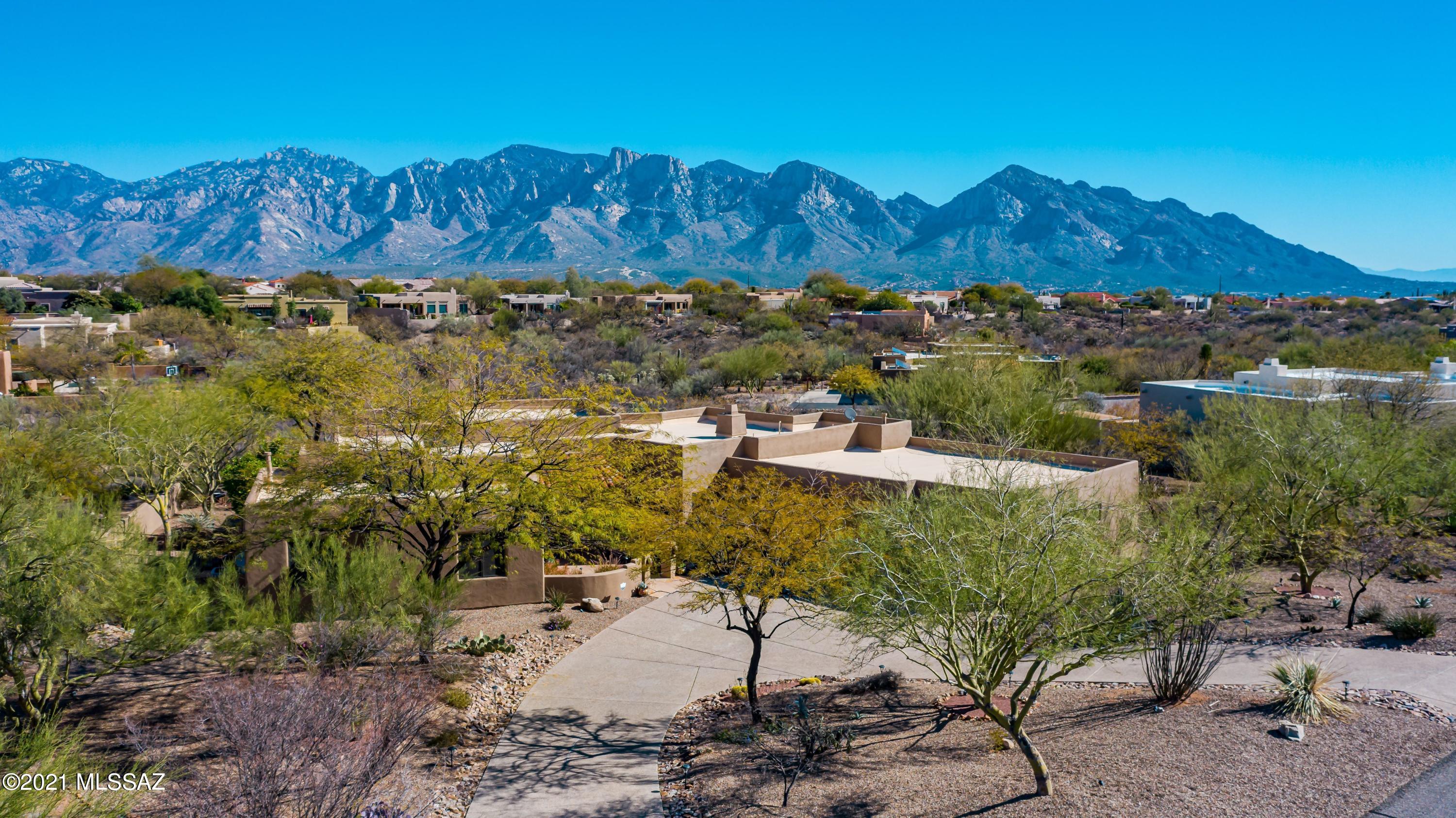 This custom Southwestern home on nearly an acre backs up to open area w/ sensational, unobstructed Catalina Mtn views! Courtyard leads you to entryway with ocotillo rib ceiling & peeled poles. Kitchen features SS appliances, granite countertops, knotty alder cabinets w/slide-outs, pantry, GE Monogram stove w/2 ovens, 6 burners. Master bd w/FP, glass doors to patio, rock grotto decor surrounding jetted tub and separate shower, large walk-in closet. Backyard has it all - Pebble Tec pool w/waterfall, spa, BBQ, kit. w/sink, FP, and fire pit. Smart thermostat and pool controls. Newer HVACs with humidifiers, exterior paint, irrigation system, and more! Oversized 3 car gar. with epoxy floors, workbench, storage, fridge, sink, and plenty of room for that oversized truck! Must see!