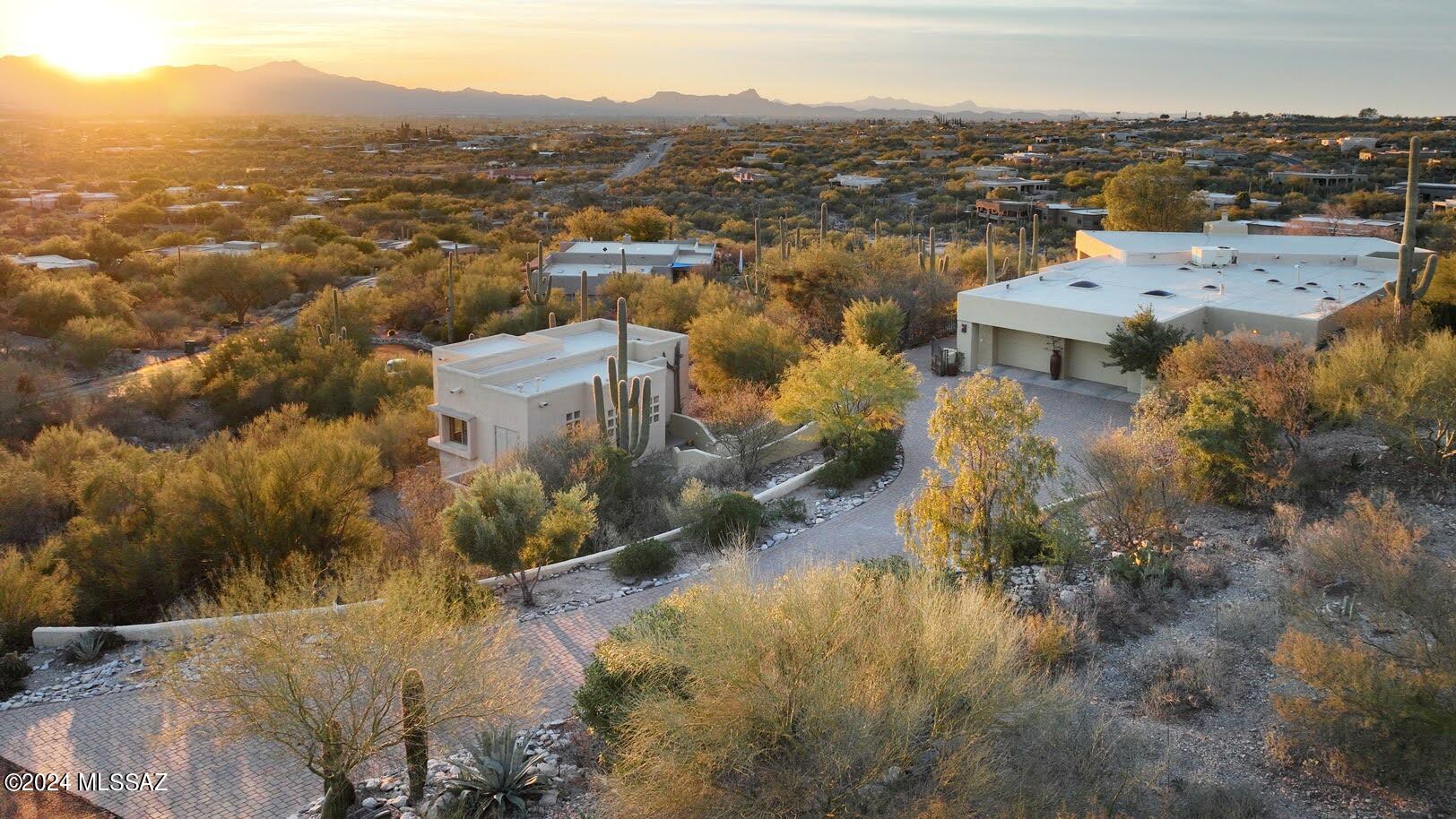 Awe-inspiring views of city lights and majestic mountains offer tranquility and inspiration right outside your windows. The main house features vaulted wood ceilings, large picture windows framing the views, clean modern lines, greatroom with fireplace, spacious kitchen, two primary suites and a spacious 3rd bedroom with an office nook. Outside, enjoy the soothing ambiance of the water features and indulge in relaxation with a private hot tub. Multiple patios provide diverse outdoor spaces, perfect for entertaining. A fully appointed 756 sq ft guest house is Ideal for accommodating family, friends, or visitors, this guest house is a retreat within itself. Nestled on over an acre of pristine desert, this residence redefines comfort and elegance with its unique features and inviting design.