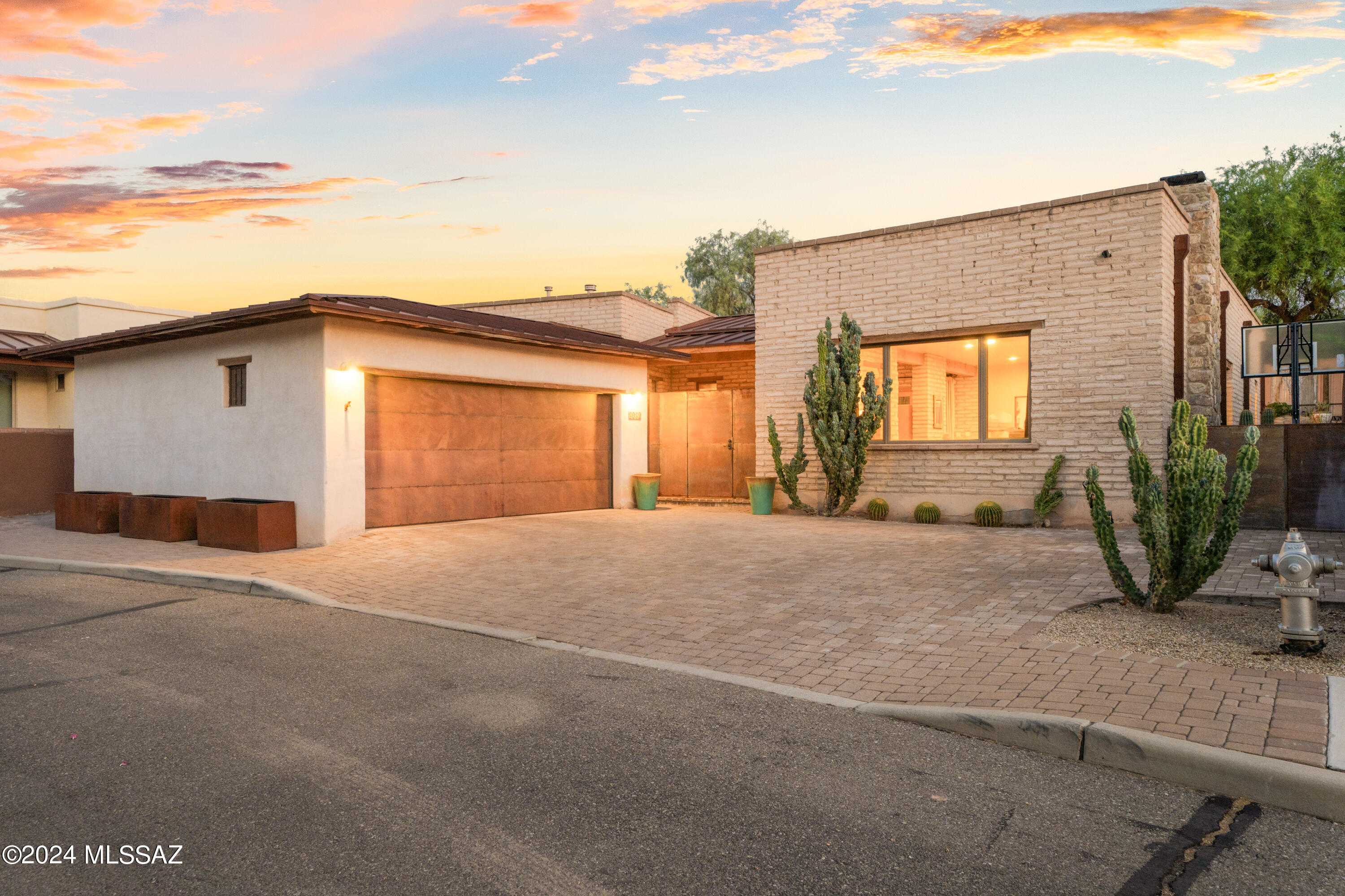 Authentic adobe brick stunner, tucked away in a private enclave. Walking distance to Rillito Riverwalk (The Loop) & Tucson Racket Club. 16'' mud adobe walls envelope this home w/ natural insulation. Metal roof, plastered walls, polished concrete floors, high-beam ceilings & beautiful fireplace. Gourmet kitchen, luxury appliances, hardwood cabinetry, casement windows, solid wood doors, plus oversized garage with rusted entry door. Architecturally unique design allows access from the dining, guest & master bedroom onto private stone patio, perfect for entertaining. Large master closet w/custom designed shelves/ drawers. This unique, high-quality, low-maintenance, eco-friendly home was built with a discriminating owner in mind. Its not just a house, it's a piece of art.