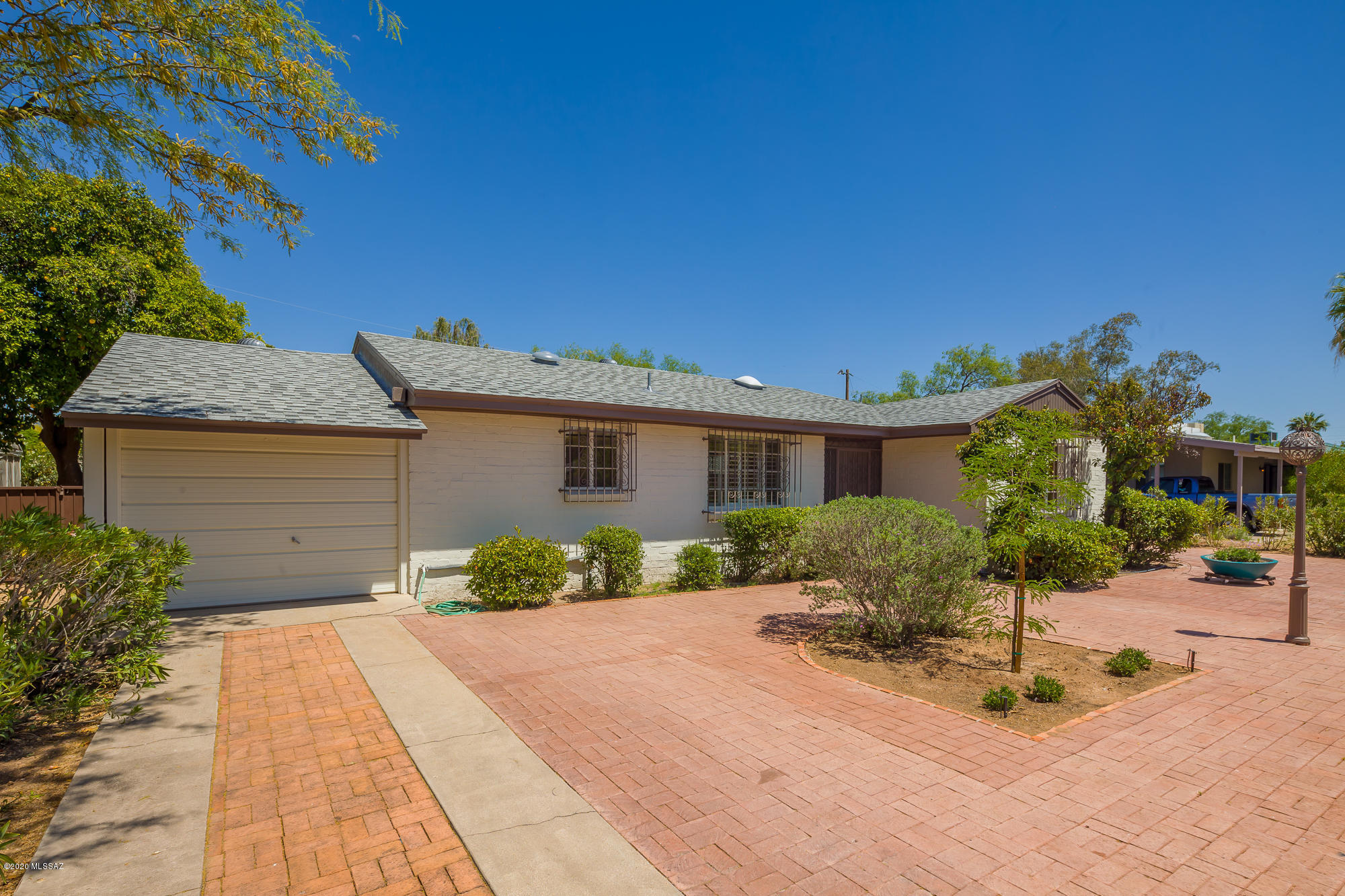 Have you been waiting for an unspoiled classic Broadmoor home? This is it! The owner has carefully brought out the original charm with some sensitive upgrades, but let most of the flavor of the '50s remain. This was a custom built home, unique in its design, and the vibe remains. From the extensive brick pavers in front and back, ceramic tile inside, the semi-upgraded kitchen, to the very cool master bedroom with a fireplace, you will love what is here, and perhaps carry on with more after the sale. The bones are great, the beautiful shingle roof is recent and the home is move-in ready.  About a mile from the U of A, the location is outstanding, and you will see your neighbors out and about, walking their pets and enjoying the sunshine or the cool of the evening. This is a must see.