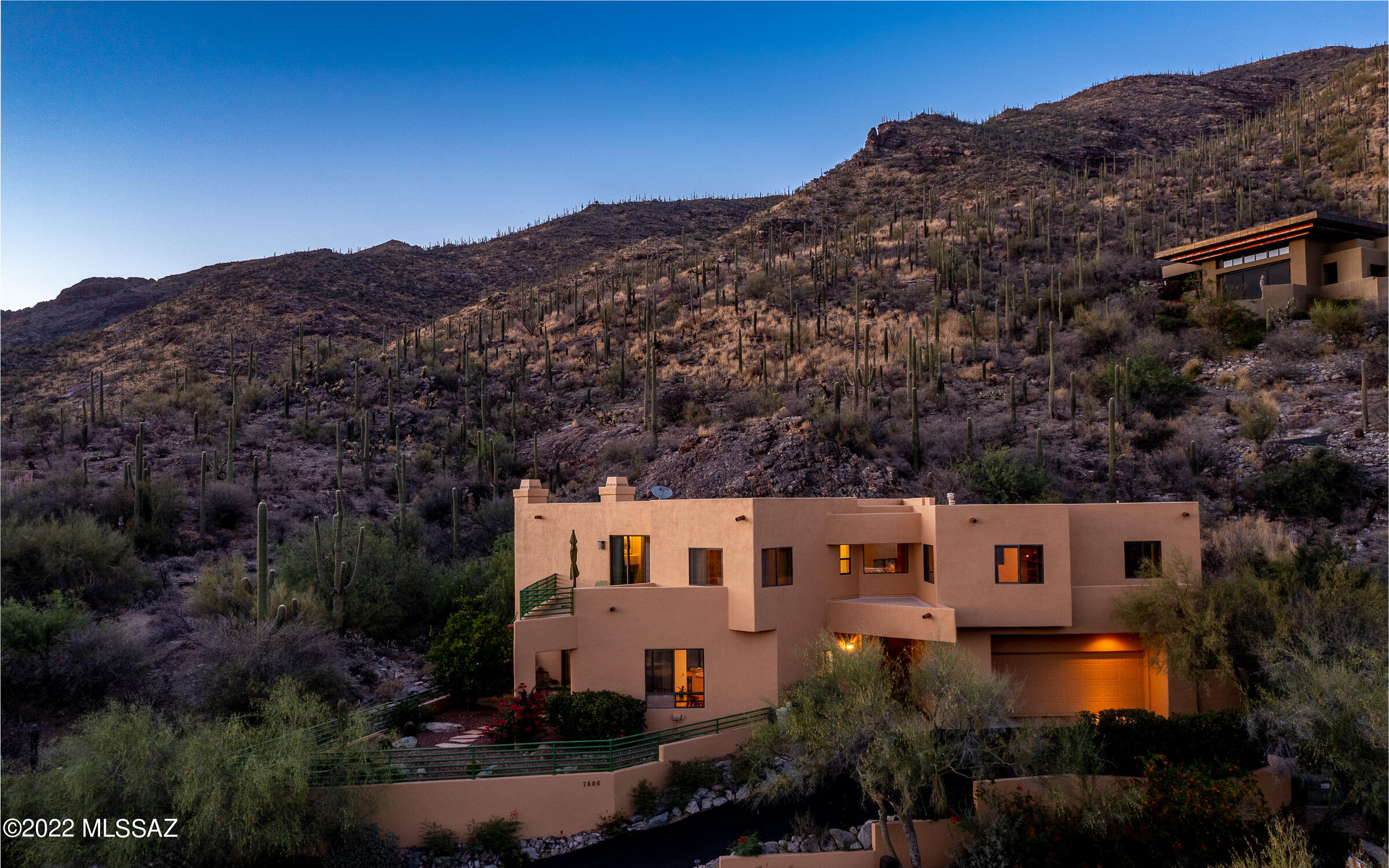 Sharp custom contemporary home designed by Ron Robinette & built by Mike Teufel. Privately nestled into the mtns featuring a flowing 35 ft waterfall to the north & twinkling city lights to the south. High ceilings & loads of windows bring in a light & bright airy feeling. Great rm features built-in book shelves, a gas fireplace & home theater. Kitchen is right-sized w/island, bar seating & casual dining space. Upstairs offers 3 ample bedrooms & a corner office w/fitted shelves. Primary suite has a fireplace & 2 secluded balconies w/mtn. & city light vistas, including a large bath, separate tub, tiled shower, double vanities, & a spacious walk-in closet. Natural stone throughout living spaces & downstairs powder rm for your guests. New asphalt driveway. Parcel to the west is available.