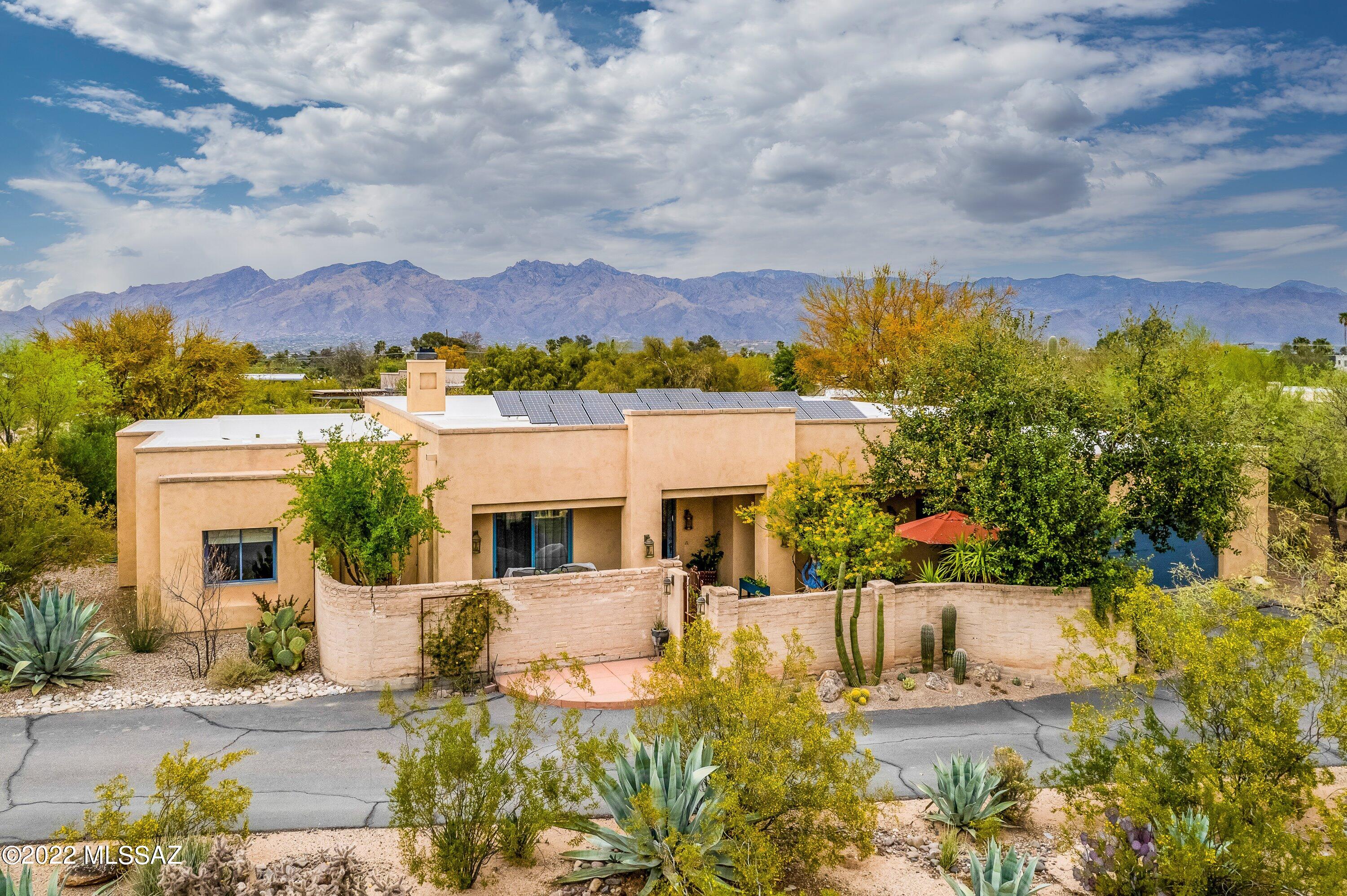 First time on the market! This custom-built, one-owner home is privately situated in the heart of central Tucson. Lush courtyard entrance w/ sitting area guides you into a bright and spacious living room with a wood-burning fireplace that is flooded with natural light from the wall of windows giving visual access to the beautifully designed backyard, desert surrounds, and amazing mountain views. Follow the beautiful polished concrete flooring throughout to the formal and casual dining areas and into the kitchen. The kitchen features custom tile surround, double oven, gas range, an abundance of cabinets, and counter space with bar seating. Access to the front courtyard with its Bistro feel is perfect for morning coffee or a glass of wine at sunset. With its true split floor plan, the elegant primary suite is situated in its own wing of the house apart from the great room and guest suites and boasts patio access, a lavish ensuite with exceptional Mexican tile accents, dual vanities, jetted tub, walk-in shower, and walk-in closet with built-ins. One bedroom is used as a home office with a large window and patio access making it a bright and enjoyable workspace. Along with the owned solar system and the thoughtfully placed skylights throughout, the home was constructed using polyurethane foam core for ultimate insulation. This combination of natural light and temperature efficiency allows for an average monthly electric bill of $37 even in the summer! Upgrades throughout this amazing home include a whole home water filtration system, custom blinds, rich knotty alder doors, instant hot water, central vac, and ceiling fans throughout. Two newer heat pumps and a newer hot water heater. The laundry room features sink, washer and dryer, and plenty of additional storage. Venture out back and unwind the minute you step into the Zen Style, carefully curated backyard with an expansive covered patio and mountain views. This home blends an unmatched combination of thoughtful design, natural views, in an unbeatable location and neighborhood. This home has been loved and meticulously cared for, and it shows.