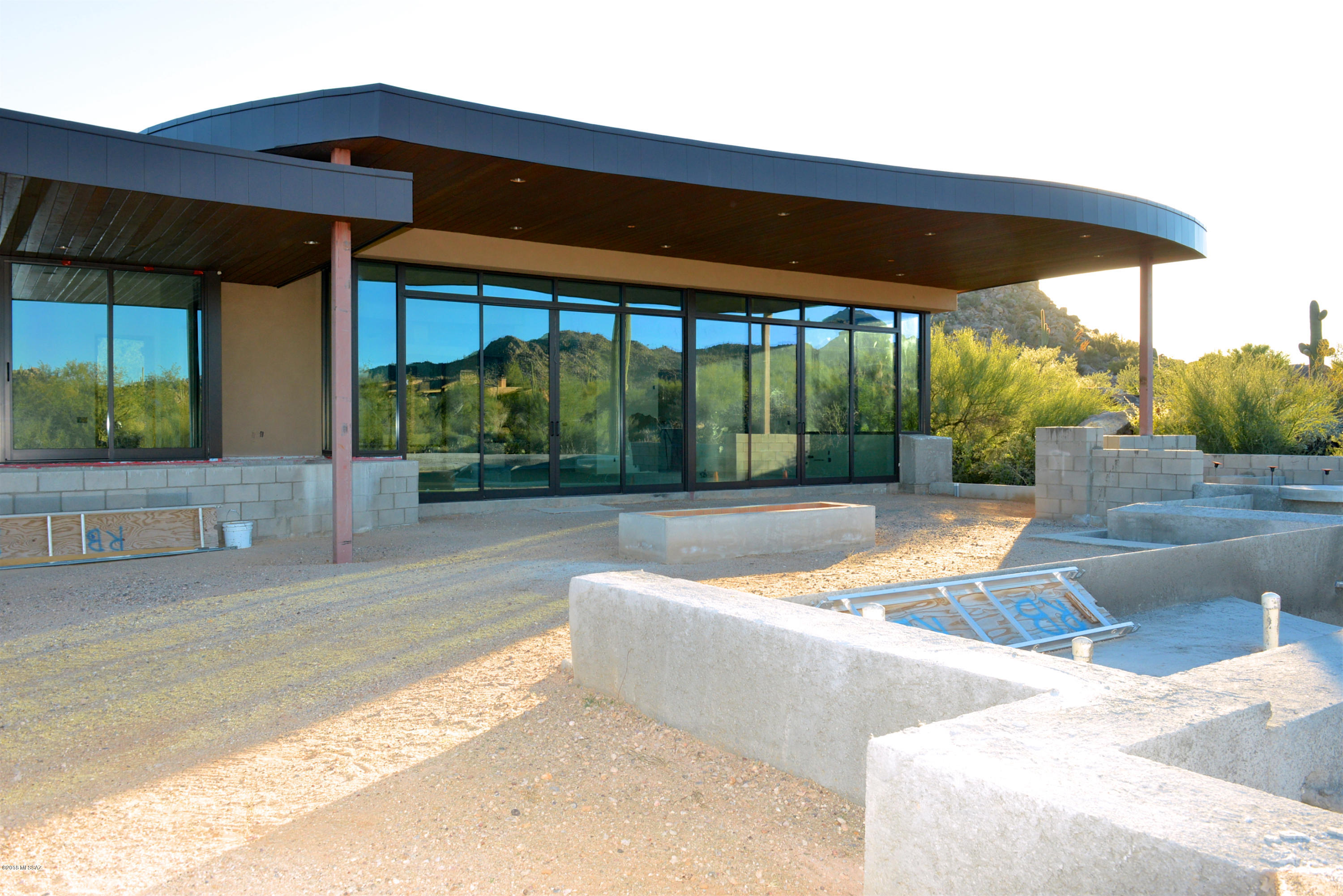 Sleek modern contemporary architecture designed by Marc Soloway to maximize light and seamlessly meld interior spaces with natural desert terrain & rugged rock outcroppings. Built by RB Construction with meticulous care, this 3,786 SF new home with split layout, 3BD, Office & 4BA invites you to enjoy the laid-back AZ lifestyle with dramatic desert & mountain views. Ready for final completion in 4 months with selected cabinet, appliance (Wolf, Asko, Sub-Zero) & flooring or you may customize those amenities. Masterfully sited facing N to 8th fairway of Phil Mickelson's Stone Canyon Club championship course, open styling creates a sense of tranquility and exclusivity. On a cul-de-sac & set back for privacy, this stunning new home offers striking views in all directions! Club Membership Req'd.
