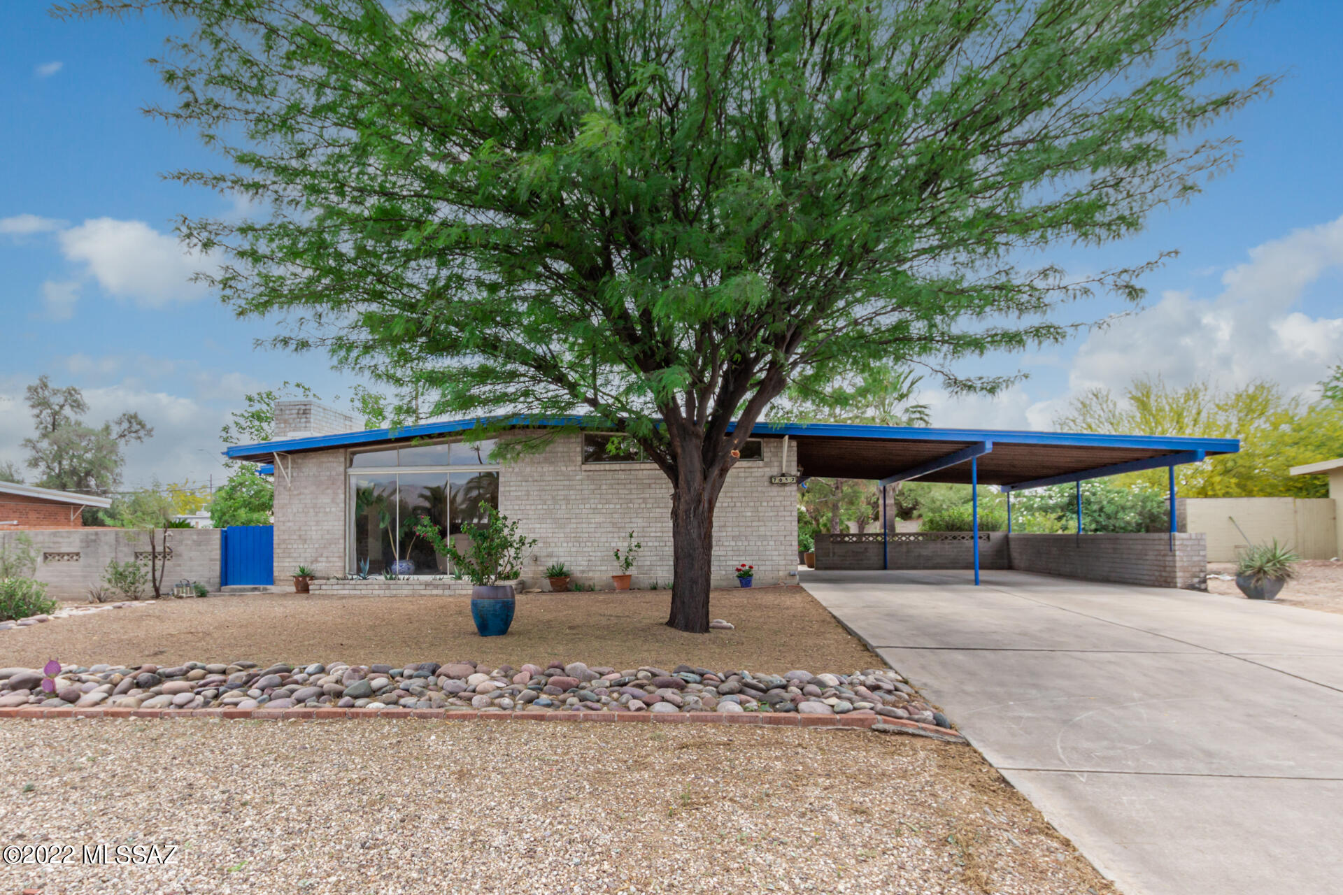 This 4BR/ 2BA mid-century modern home with views of the Catalina mountains and generous natural light has a spacious walled yard for kids and pets, mature trees, plus tons of storage.  New HVAC installed in 2022 along with freshly renovated evaporative cooler.  Roof freshly coated with premium elastomer in spring 2022. Large primary suite is privately located in front of home with balance of bedrooms and main, wheelchair accessible bathroom with a roll-in tiled shower and low countertop located beyond the open kitchen and dining area. Utility room with plenty of storage next to kitchen and an additional high roof carport with large storage building accessed off alley. Conveniently located to bus route, Hudlow elementary school is only one block away and employers like TMC and DMAF are near