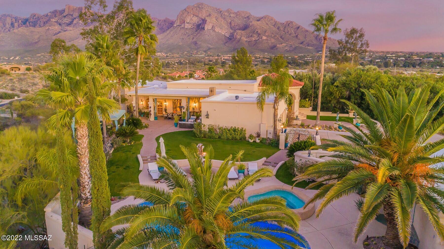 HILLTOP RESORT! Fully developed gem of a property in Oro Valley on almost two acres. Atop the hill is a pool, fountains, and vaulted entryway. Attached 2-car and detached 2-car garages provide excellent parking plus open parking for 9+ cars.  Ext. amenities include patio areas, cov'd deck, Cantera fireplace in rear patio, pool, spa, pool bath, and tennis court. Interior features incl. newer plumbing, electrical, hdwood and tile flooring, remodeled kitchen w/ Viking appls, alder cabs, granite c/tops. Large master suite with Pusch Ridge views and remodeled full bath w/ Italian marble cntrs, steam shower, and Jacuzzi tub. Crystal chandeliers, Lucent lighting, dazzling dining, and library/den add to this exceptional home. No HOA. See it today! Landscaping includes mature palms, giant cypress, a dozen mature fruit trees, bougainvillea, Texas Sage, and grassy lawns...all extend a warm welcome.  Spectacular Pusch Ridge mountain views and surrounding valley views won't disappoint. A giant 200-year old saguaro stands guard just outside the primary bedroom window with full mountain views.  Too much to list, please see attached features lists.