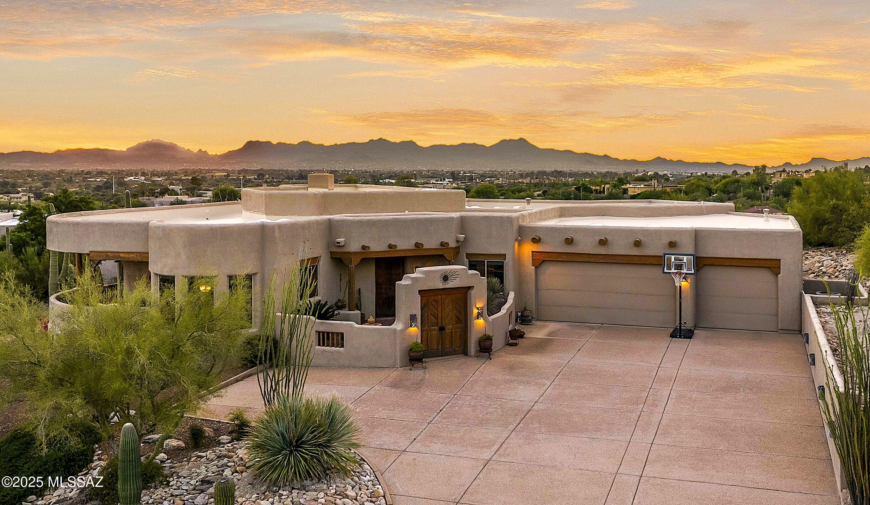 Nestled in a gated Foothills community, this lovely Santa Fe home sits on an elevated .82 acre lot capturing stunning city light views. Charming courtyard entry welcomes you into spacious living areas highlighted by gorgeous high wood beamed ceilings & dramatic 2-way fireplace anchors the living & family rooms. Well appointed kitchen offers an island, nook & lg pantry while the fabulous dining area features expansive windows that frame the views. Generous primary incl a lg walk-in closet, roomy shower, sep tub & dual vanities. 3 addl bedrooms, 1 w/ensuite bath provide flexible space for guests. Enjoy Tucson's indoor-outdoor lifestyle on the huge covered patio w/built-in BBQ overlooking saguaro-studded landscaping & a sparkling pool. 3-car garage completes this exceptional retreat.