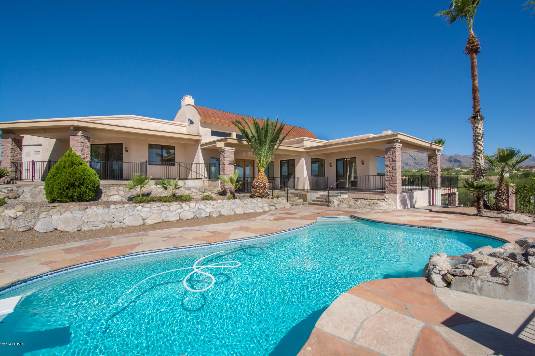 Situated in the Swan Ridge gated community in District 16, this contemporary masonry/stucco foothills home offers security, privacy and breath-taking views of both city and Catalina Mountains from its custom wrap around deck. House has fabulous curb appeal with dramatic front entry and copper dome roof. Inside is tasteful appointed throughout with double-door entry, dramatic high ceilings, custom flooring, and over-sized gourmet kitchen with large chef's island; and bathrooms in three of the five bedrooms. Outside is resort-like landscape adorned with palm trees around the swimming pool!