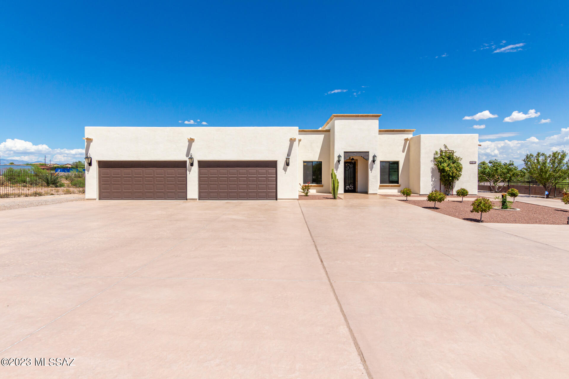 Wow is what you will feel while looking at this property and home. The acre + lot is fully enclosed with custom touches everywhere and views galore!  The entry of the home boasts extended textured / colored concrete with a circular drive and 2 gates for access. Upon entry you will notice the polished concrete floors, 16' entry and 12' ceilings throughout. The floor-plan offers a split bedroom layout. The master has soaker jacuzzi tub, separate shower, double vanity, and custom closet. There are 2 additional en-suites, multiple living areas, extensive LED recessed lighting, and knotty alder cabinets, baseboards, and doors. Each of he 4 garage bays offer 4' extensions. Enjoy evenings under the covered patio with extended custom pergola and grilling area that offer mountain and city views.