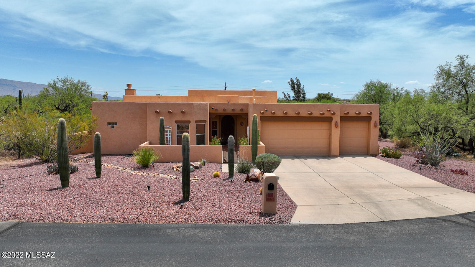 This charming Santa Fe style home is nestled on the private, one acre+, cul-de-suc lot in desirable, small, gated Rancho Camino Palo Verde community. You will enjoy spending time on extended, flagstone covered patio, walled yard w/sparkling pebble-tech pool & spa. The home features open concept kitchen with plenty of kitchen cabinets, exposed vega beams, gas fireplace, pleasant view windows. Split floor plan allows for privacy for your guests. Features include - high ceilings, ceiling fans, wooden plantation shutters, tankless water heater, waterproof laminate flooring in three bedrooms and living space, three car garage & list goes on! Den is perfect for working from home! Tanque Verde school district. Within minutes drive from golf course, hiking trails, grocery stores, etc. Great house!