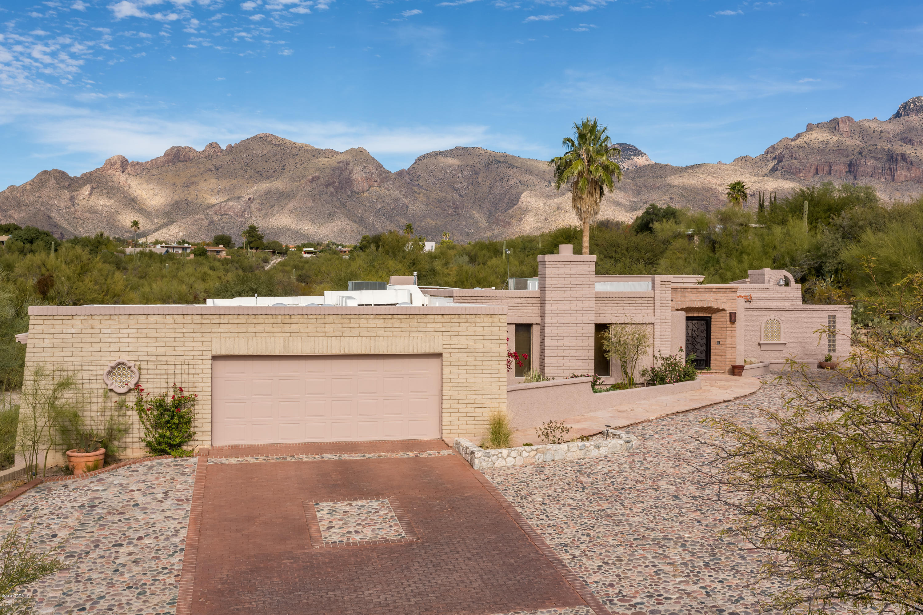 Come experience the warmth and charm of this private oasis.  Whether you are entertaining guests at the pool or retreating away to reflect by the rippling water of the koi pond, this must-see hacienda has it all.  Watch the clouds roll over the mountains from 1 of the 3 private patios.  Warm up with friends under the stars near the fire pit or curl up with a book next to the fireplace in the master suite.  Play games with your family in the sport court or make use of the half ton lift in the RV garage.  Private guest quarters and 5 total bedrooms give you and your family the space you need to truly enjoy your time together. Conveniently located minutes away from shopping and within the Catalina Foothills school district, this truly is a special and unique opportunity! Come see it today!