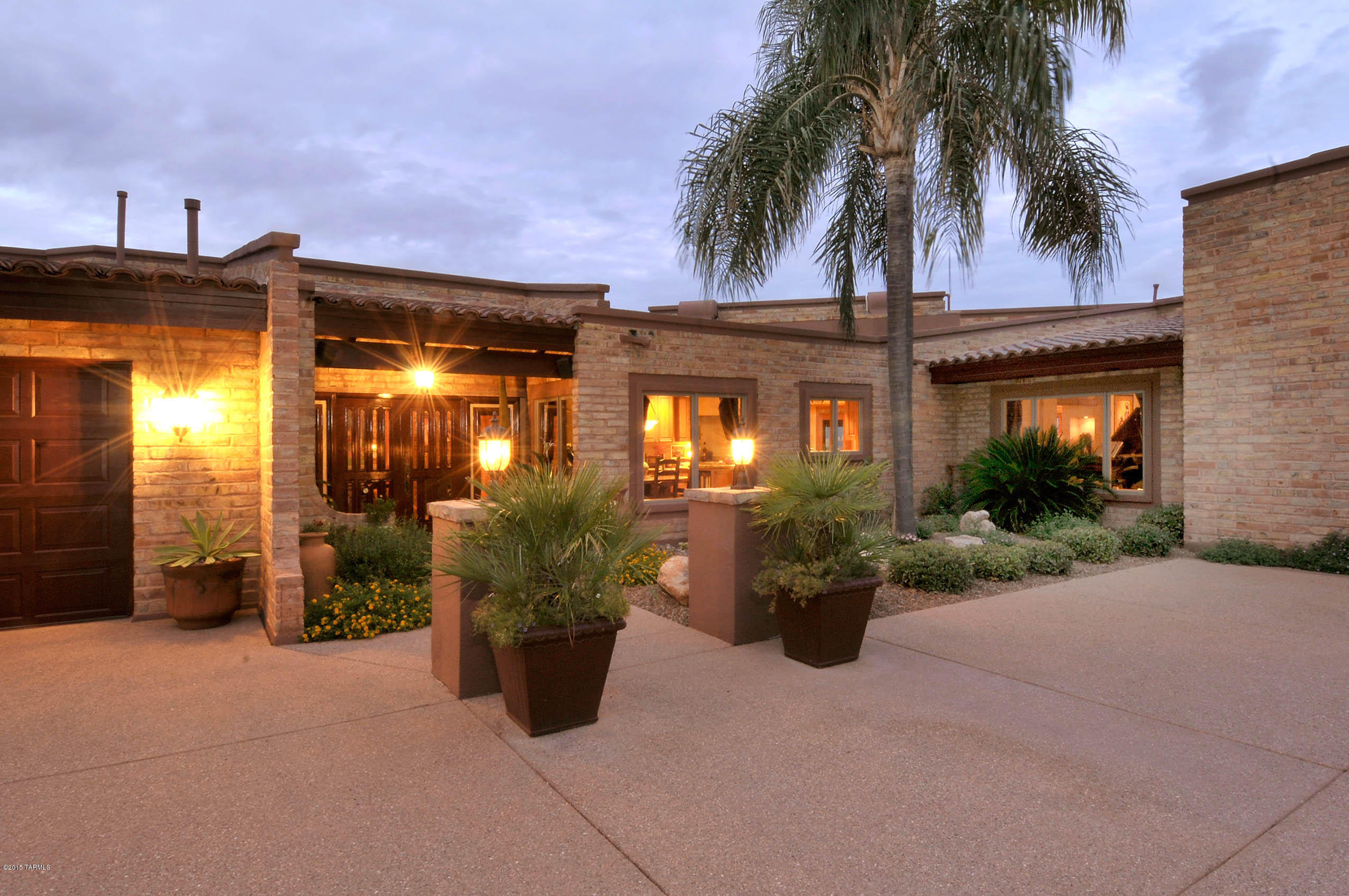 Stunning one-of-a-kind classic Ultra-Custom Desert soft Contemporary high above Tucson at the top of Skyline C.C. with breathtaking City, Sunset and Mountain views. Casual elegance, spacious guest parking, grand gallery entrance, NO STEPS anywhere, exposed adobe interior walls, custom windows and doors, beamed ceilings, stone and hardwood flooring, walnut cabinets in gourmet kitchen, dramatic views form every window, indoor pool that opens to the outside in controlled environment, fantastic master-suite, wrap-around patios designed to capture the views and essence of the Tucson Lifestyle, great-room like living room, eat-in kitchen, open flexible floor plan with 5 bedroom main house or 3 bedrooms + den and office - all in immaculate pristine condition. Impeccably maintained landscaping.