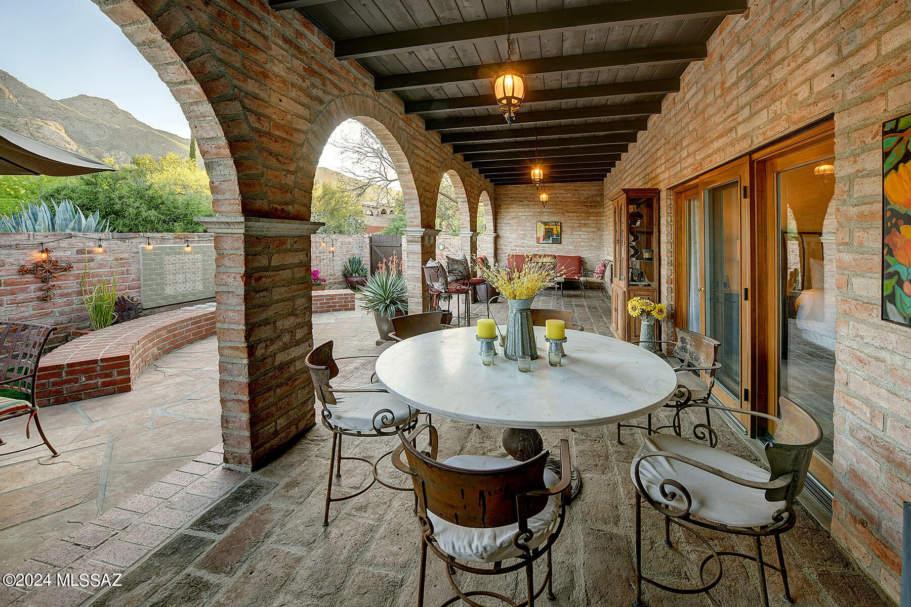 That rare blend of adobe charm, yet updated to perfection. Picture a welcoming wrought iron entry that  leads to living spaces that exemplify the casual Tucson lifestyle. Custom kitchen with seating that calls for everyone to gather.  Wall of glass doors lead to brick patio with amazing views of the mountains.  The primary suite echos the same feel with glass doors also leading to the patio.(outdoor living room?) The den could be 3rd bedroom, but what a shame except for the occasional guest.  Think glass french doors opening to the great room area.  However, a Jack and Jill makes both of these rooms flexible.  The ensuite bathroom for the primary is perfect.  I could go on but if classic simplicity is what you want....  I don't think in 30 years of real estate I have seen better.