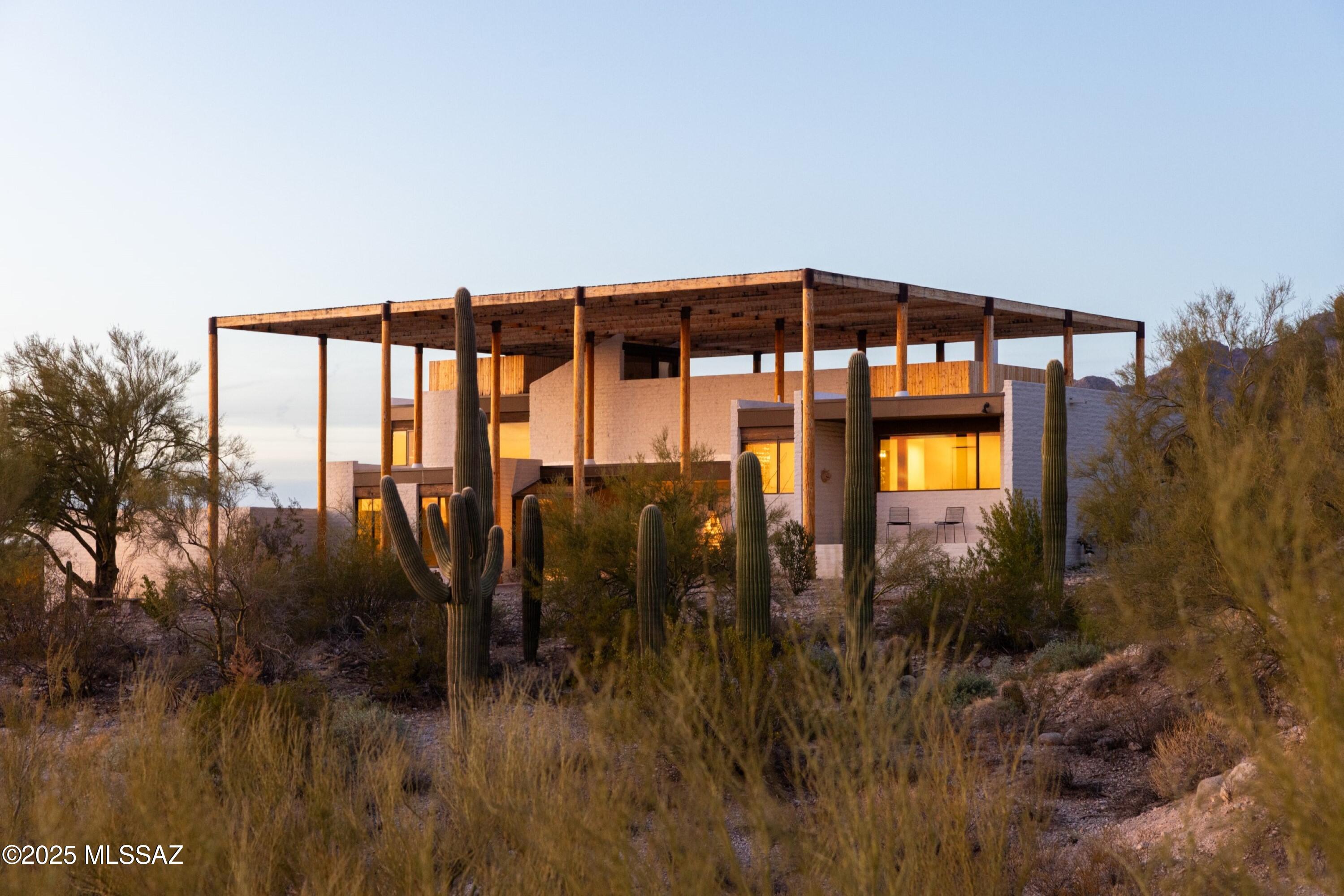 Experience a once-in-a-lifetime opportunity to own the renowned 'Ramada House' in Tucson, Arizona, a masterpiece designed by the acclaimed architect Judith Chafee. This privately gated estate spans 8.6 acres, featuring lush desert vegetation and breathtaking views of both the city and mountains, nestled in the prestigious Catalina Foothills Estates. Judith Chafee (1932-1998) was a pioneering architect whose most renowned work, the Ramada House in Tucson, Arizona, has left an indelible mark on modernist architecture. Completed in 1975, the Ramada House stands as the pinnacle of Chafee's career, embodying her innovative approach to desert modernism and her unwavering commitment to creating buildings that harmonize with their environment. The Ramada House is widely considered Chafee's most significant work, showcasing the full maturity of her architectural vision. Her education at Yale University and her work with luminaries such as Eero Saarinen and Walter Gropius laid the foundation for the unique design principles that found their fullest expression in this extraordinary residence.

The Ramada House represents a masterful synthesis of modernist principles and regional building techniques, setting a new standard for desert architecture.

As Chafee's most celebrated work, the Ramada House has been widely recognized in the architectural community. It has been featured in numerous publications, including a cover appearance in Architectural Record as a Record House Award winner. This recognition underscores the innovative nature of Chafee's design, which has become a cornerstone for architects studying desert modernism.

The Ramada House's significance to Arizona's architectural heritage is further cemented by its inclusion on the National Register of Historic Places in 2006, a rare honor for a relatively young building at the time. This designation not only acknowledges the house's architectural importance but also ensures its preservation for future generations to study and admire.

The enduring impact of the Ramada House is reflected in recent publications and exhibitions dedicated to Chafee's work. The book "Powerhouse: The Life and Work of Judith Chafee" by Christopher Domin and Kathryn McGuire prominently features the Ramada House as a highlight of Chafee's career. Additionally, the traveling exhibit "Judith Chafee: Framing the Desert" showcases the Ramada House as a central piece, bringing this architectural marvel to a wider audience.

With its distinctive lofted grid made of wood slats inspired by traditional Tohono O'odham building techniques, the Ramada House exemplifies Chafee's skill in integrating indigenous design elements with modern architecture. This approach not only created a unique aesthetic but also demonstrated a profound understanding of the local climate and culture, establishing the Ramada House as a seminal work in the field of regional modernism.

The legacy of the Ramada House continues to inspire architects and students in Arizona and beyond. It serves as an exemplary model for sustainable, regionally responsive architecture that respects its environment while pushing the boundaries of modernist design. The ongoing interest in the Ramada House ensures that Judith Chafee's most significant contribution to architecture will continue to be studied, celebrated, and influential for years to come.