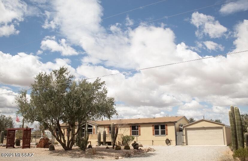Come visit this well maintained and upgraded  manufactured home on a paved road. This home has three bedrooms, two bathrooms, a den or office, large kitchen with an island, built in hutch in dining area, huge family room with large built in entertainment center and built in desk in hallway. The home has beautiful landscaping in the front and the back of the home. The backyard includes a greenhouse, large closed-in garden, two sheds and a truck port. Also, the backyard has several fruit trees such as: lemon, orange and a cocktail tree. This home is sold AS IS.