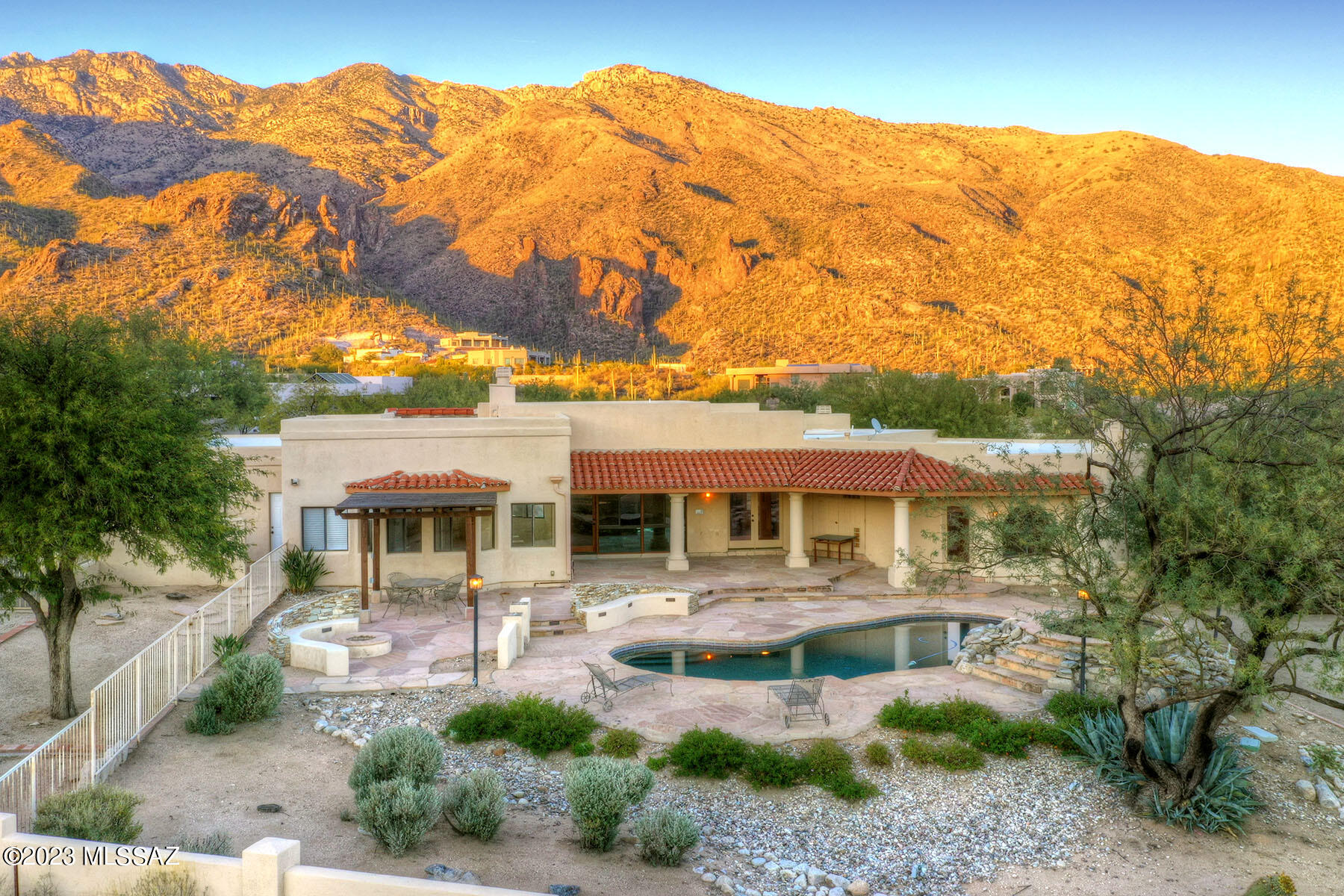 Stunning soft contemporary located in the prestigious Catalina Foothills enclave of Alta Vista. This original owner custom single story home features four bedrooms & three bathrooms and offers breathtaking Santa Catalina Mountain views as well as twinkling Tucson city light views - a quintessential Tucson estate home.

As you enter through the front double doors, the welcoming foyer leads you to the living & dining areas that take advantage of every view. The living room offers striking mountain views through arched windows, a corner gas fireplace, a built-in serving area that is plumbed for water, soaring ceilings and the adjacent dining room features city views, modern chandelier and has French doors that lead to the outdoor covered patio.
The gourmet kitchen has custom wood cabinetry with copper laminate inlays (extras include built-in spice rack & pull out wooden cutting board), oversized center quartz island (with electricity) & breakfast bar, Franke double sink, pendant lighting, reverse osmosis, walk-in pantry, built-in desk and breakfast nook with a fun & whimsical chandelier.  Enjoy fabulous entertaining and dining outdoors on the front patio watching the incredibly vibrant sunrises & sunsets while immersing yourself in the beauty of the Sonoran Desert. The family room is adjacent to the kitchen and features a gas fireplace, built-in speakers, custom niches, in-floor electrical receptacles and access to the pool & spa.

Relax & unwind in the main bedroom suite with corner gas fireplace, custom Saguaro ribbed window covering and access to the backyard.  The luxurious spa like bath offers a jetted tub, walk-in shower with rain tree as well as handheld fixtures, separate dual vanities with quartz counters, contemporary lighting, large walk-in closet with mirrored doors, incredible custom storage and spectacular mountain views.

Luxury living at its best with a resort style backyard showcasing a refreshing pebble-tec pool & spa with water feature & remote controls, gas fireplace, ramada, extended covered patio, flagstone, misting system, stacked stone accent walls, multiple outdoor seating areas, as well as a separate enclosed area that could be used for an organic vegetable garden, playground, corn hole competition or even a dog run.  This dramatic setting offers an inviting & relaxing atmosphere to entertain both family & friends year round while enjoying the indoor/outdoor lifestyle so prevalent in Tucson.

Sited on .93 acre, this incredible space maintains a sense of seclusion in the lush Sonoran desert offering native vegetation, drip irrigation and natural wildlife. Many, many upgrades including oversized three car garage, separate laundry room with sink & plenty of wood cabinets, central vacuum, water softener, skylights throughout, built-in speakers, lighted ceiling fans, porcelain tile floors and storage galore! Well maintained home with two zoned HVAC units (2018 & 2019), two water heaters (2016), pool equipment (2019), termite warranty with Truly Nolan. Close to great hiking at Sabino Canyon, world class golf & resorts and fine dining. District 16 schools. Truly a remarkable residence.